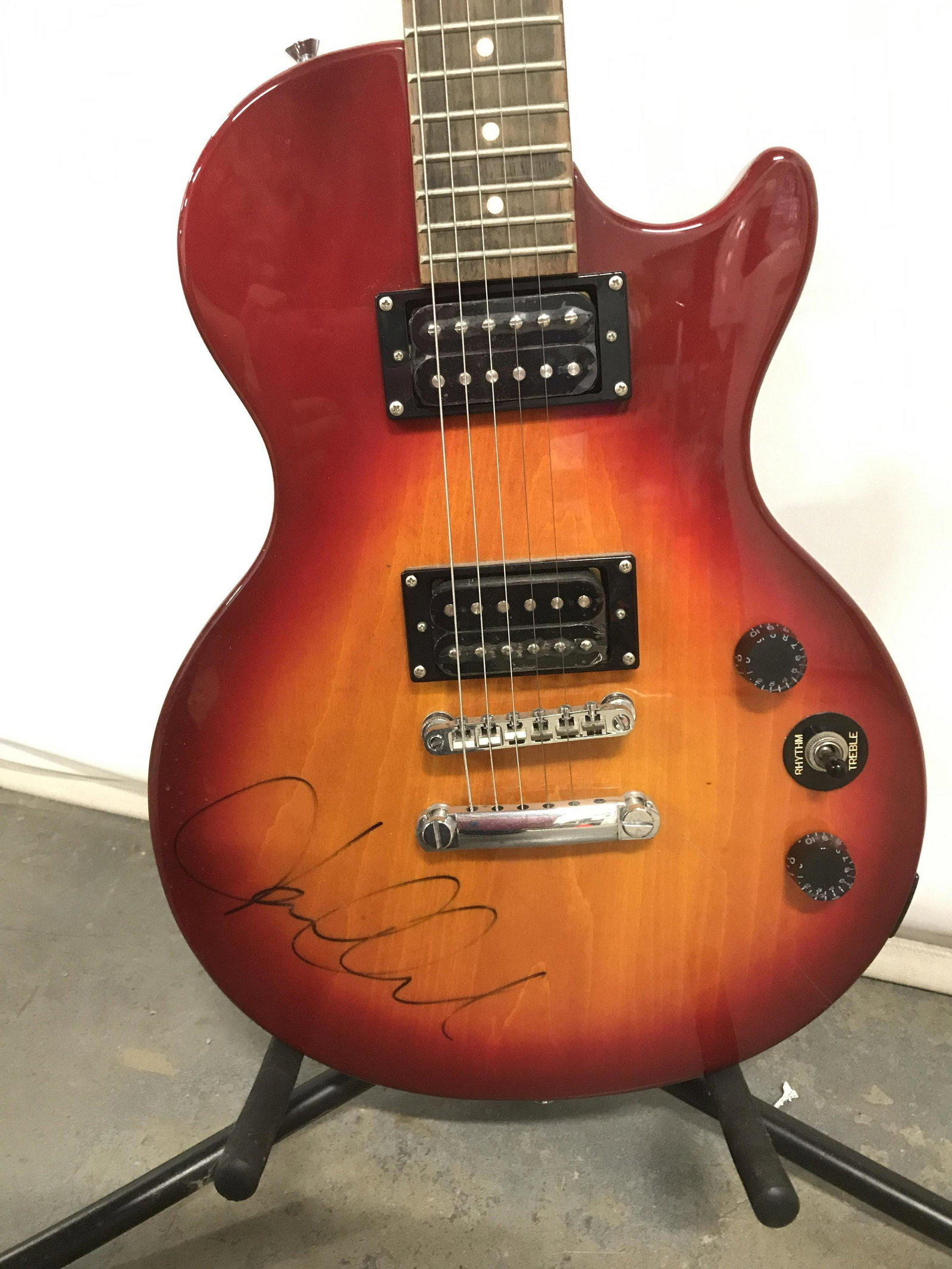 EPIPHONE Special Model Electric Guitar: EPIPHONE electric guitar, includes guitar stand. Autographed illegibly. Measures approx 39 inches long, 13 inches W. Wear is consistent with age and use. Guitar, electric guitar, instrument, string in