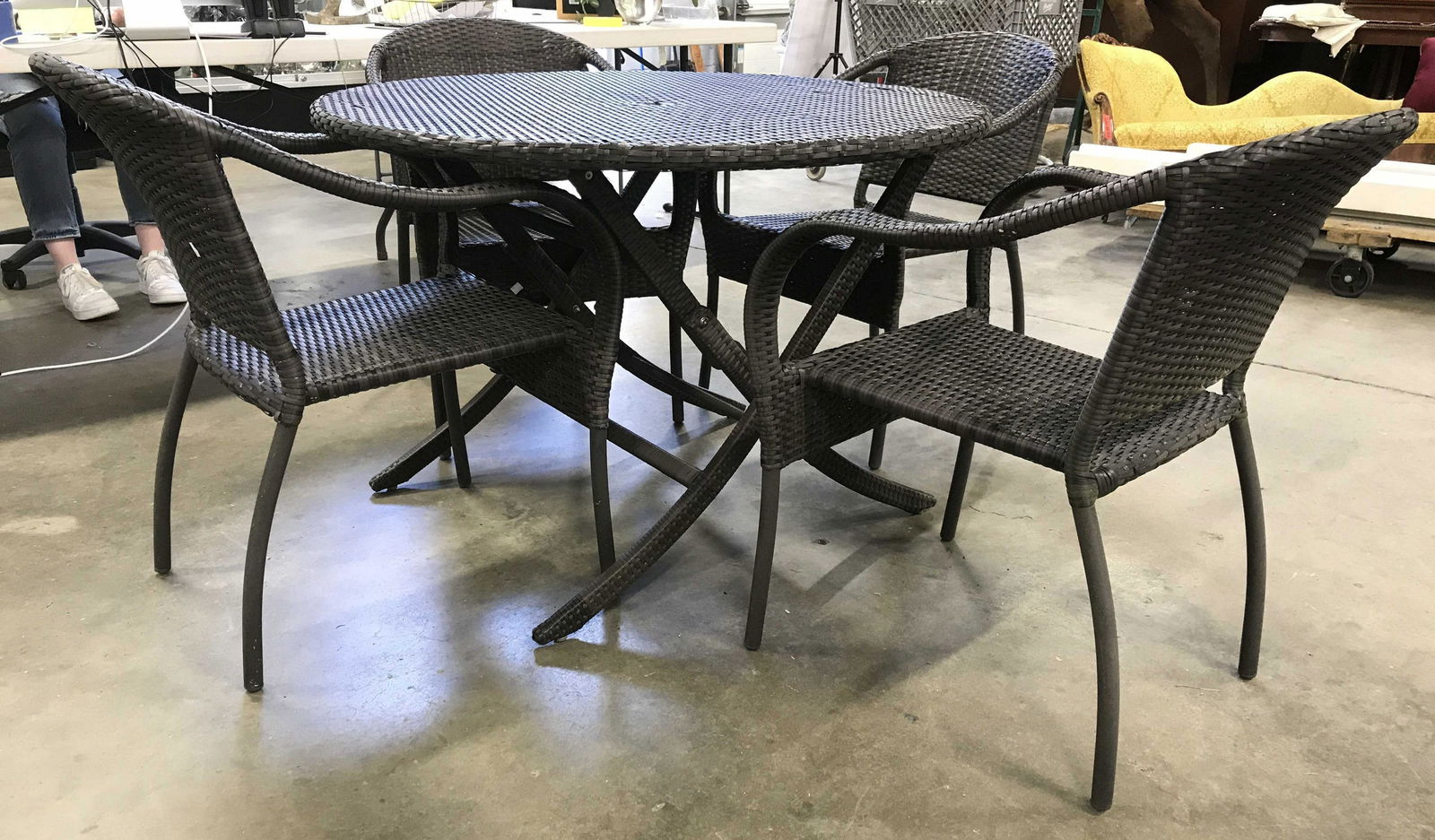 Set 5 Patio Dining Set Table & Chairs: Lot includes patio table & chairs. Each piece is brown toned with woven structures. Table top has circular shape with umbrella hole in center. Table folds. Table measures approximately 29 inches tall
