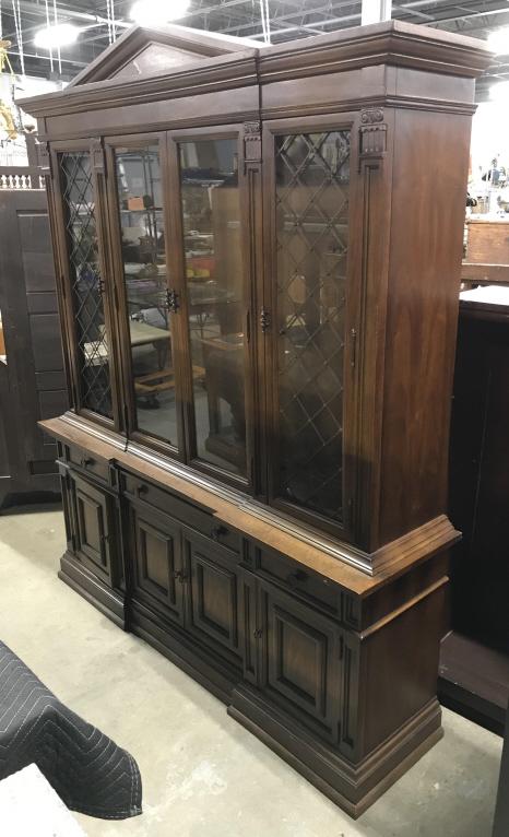 Carved Wooden DREXEL China Cabinet: China Cabinet is wooden, possibly vintage. Piece is marked DREXEL on backside. Piece has 3 drawers each with metal floral Detailed knob style handles. Piece has 3 cabinet spaces. Center cabinet space