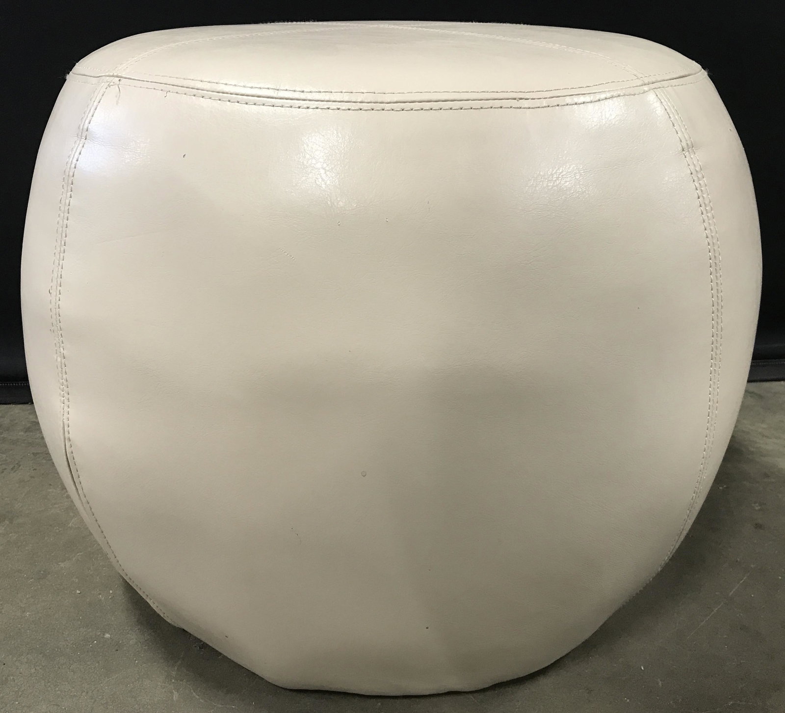Leather Upholstered Ottoman Footrest: Ottoman is tan toned. Piece is upholstered in what appears to possibly be genuine leather. Ottoman, footrest, leather ottoman, upholstered ottoman, leather footrest. hassock, seating, home furnishings