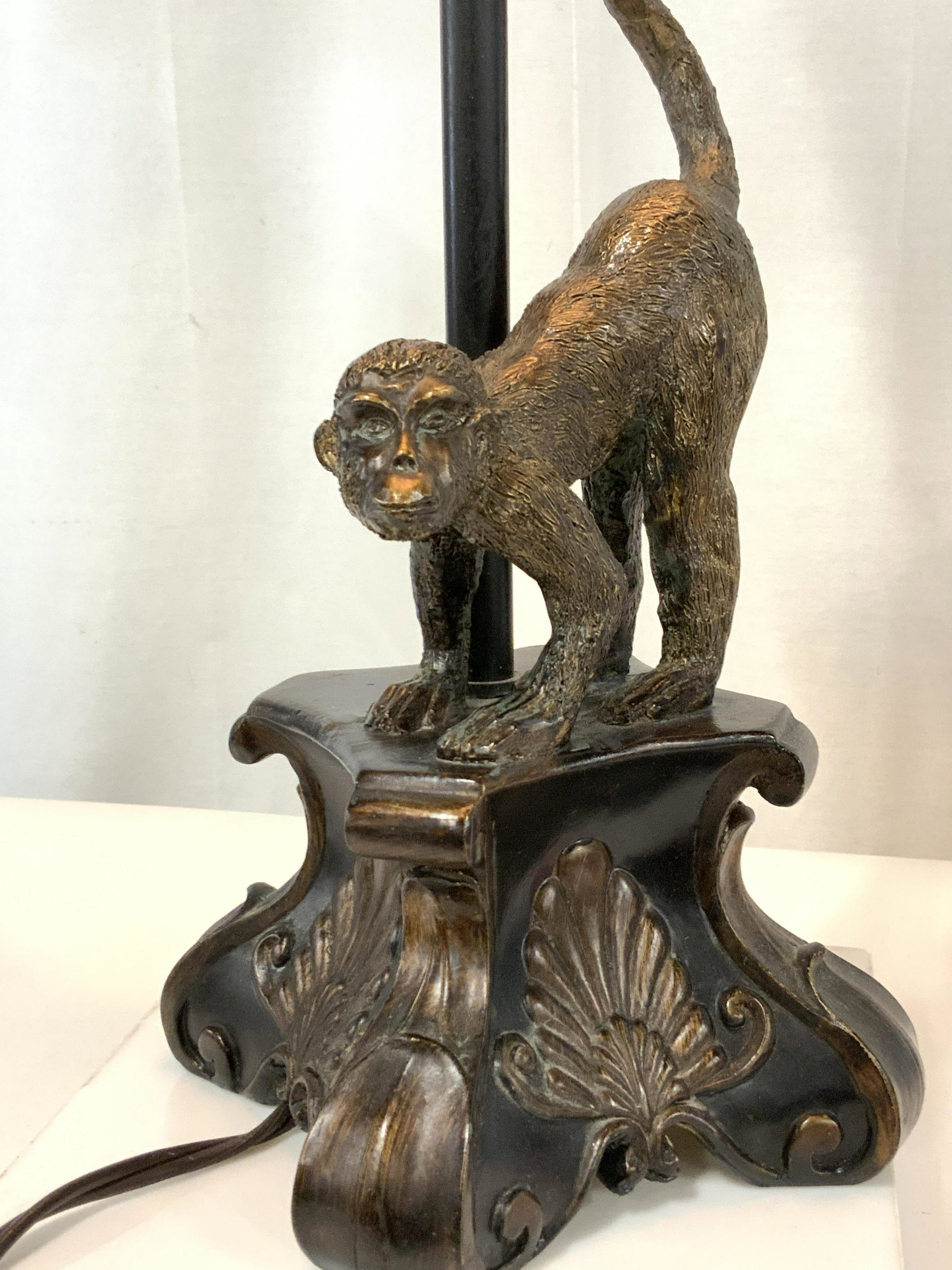 MONKEY FIGURAL LAMP, Brushed Bronze Metal: Primitive jungle theme lamp, plush lampshade with jungle stripes and looped thread rims. Long bar pedestal with monkey figural perched on a wood/composite lamp base stand with tail curled around bar. 