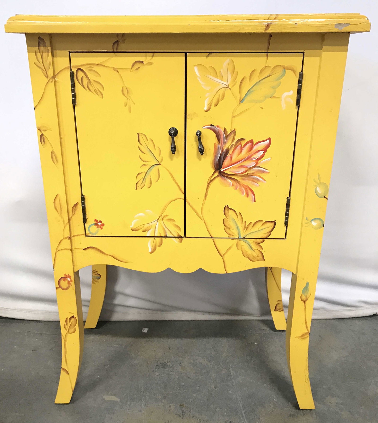 Vintage Painted Wooden Side Table W Cabinet: Side table appears to be wooden. Piece is yellow with painted multi toned floral and leaf detail. Appears to be hand painted. Piece has cabinet doors which open to storage area. Piece measures approxi