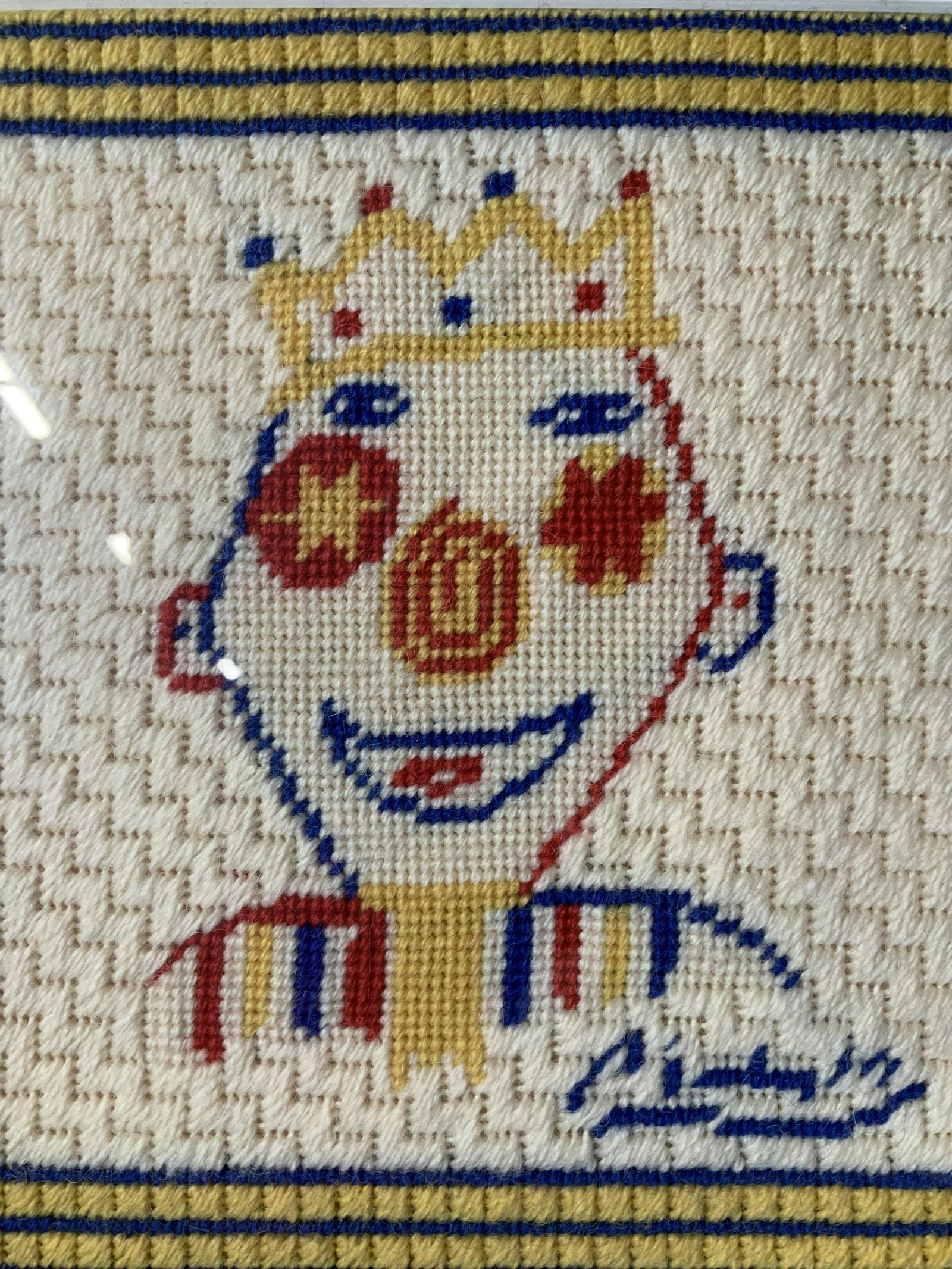 PABLO PICASSO The Clown Needlepoint Artwork: needlepoint depicting PABLO PICASSO The Clown. reads in needlepoint ‘Picasso’, subject a clown in a crown, measures 14 1/8 x 14 1/8 inches, gold toned metal frame, some surface wear to frame but o