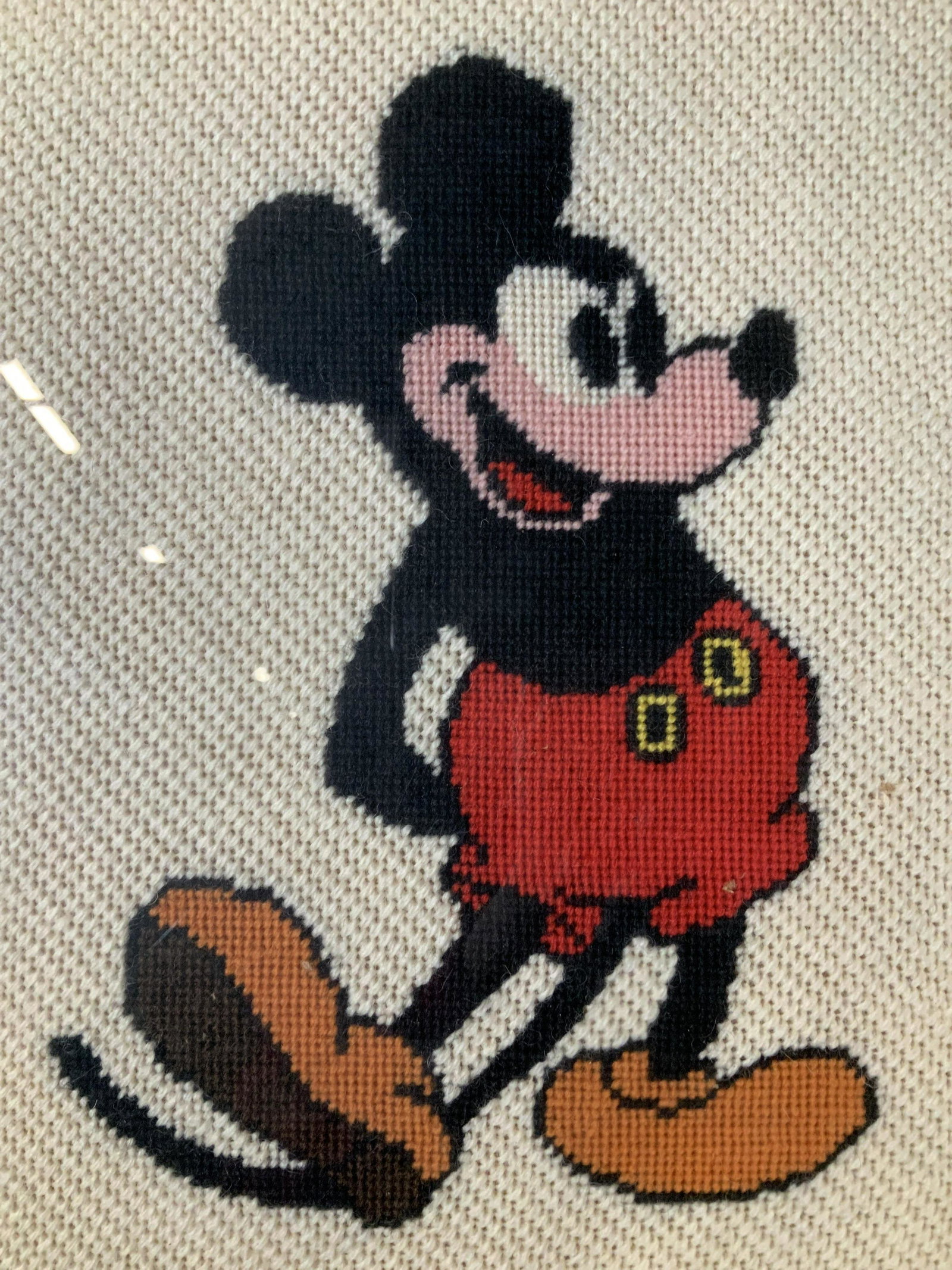 Mickey Mouse Needlepoint Artwork: Mickey Mouse Needlepoint Artwork, stamp to reverse reads ‘Keen Framing’, subject Mickey Mouse, measures 18 1/2 x 15 1/2 inches, black and red wooden frame, some surface wear to frame but overall i
