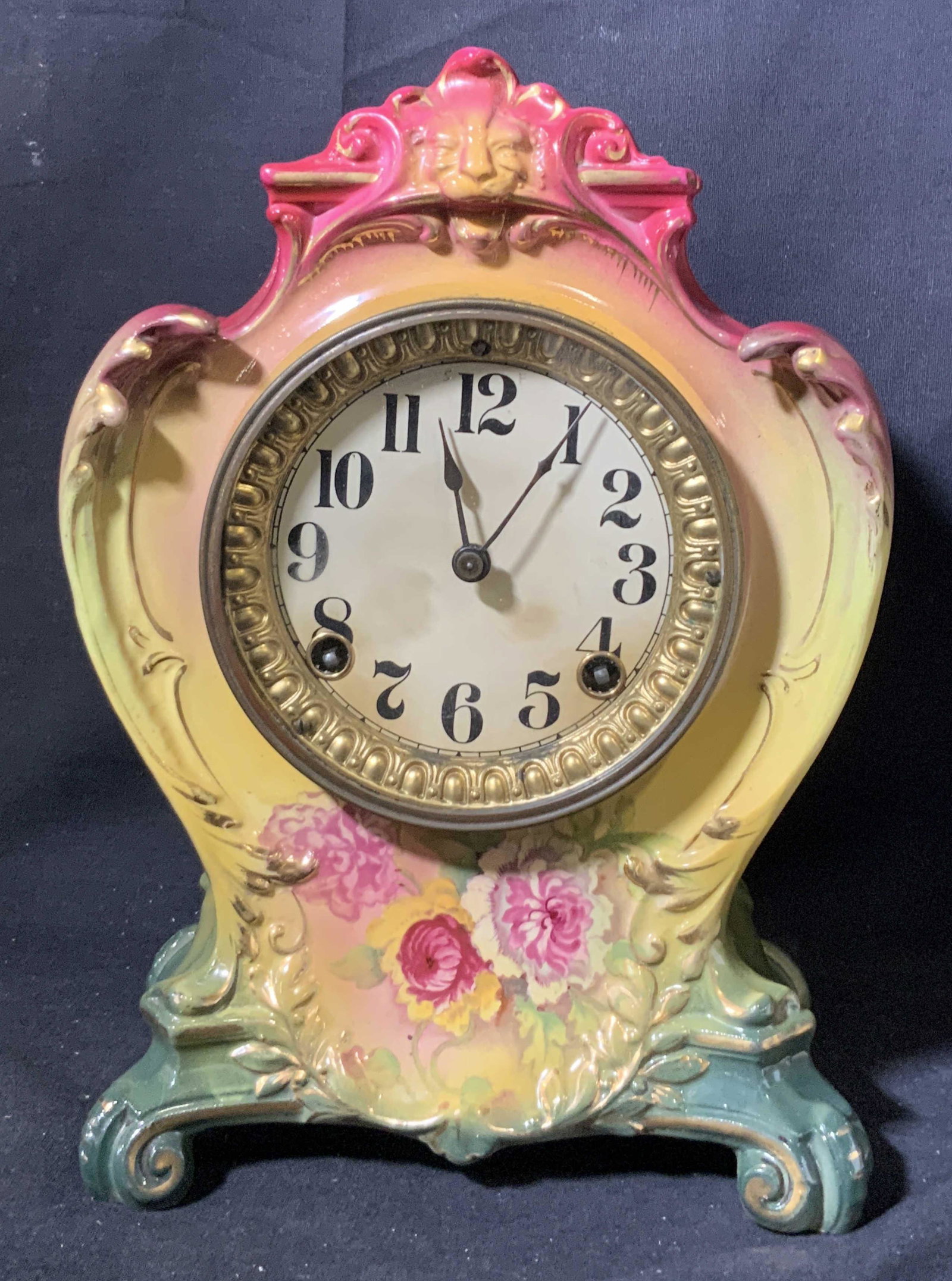 Royal Bonn Germany Ansonia Antique Porcelain Clock: Royal Bonn hand painted Ansonia clock, possibly antique. Clock depicts flowers and a lion’s head, gilt lining throughout. Base of clock has decorative feet. Clock not tested, inside includes pendulu