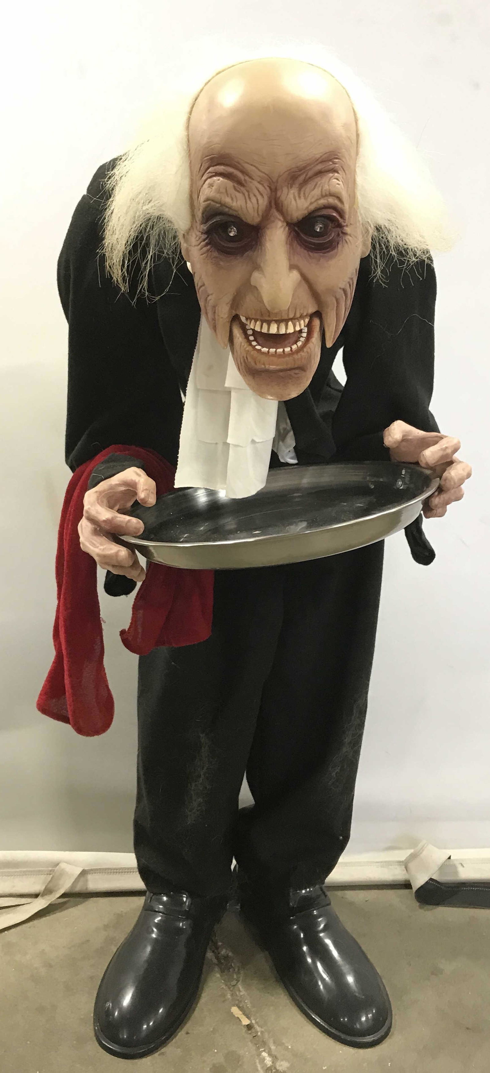 Creepy Butler Halloween Decoration: Electronic Halloween decoration. Resembles a demonic butler holding a metal tray. Measures approx 36 inches H, and 12 inches W. Wear is consistent with age and use. Demonic butler, creepy decorations,
