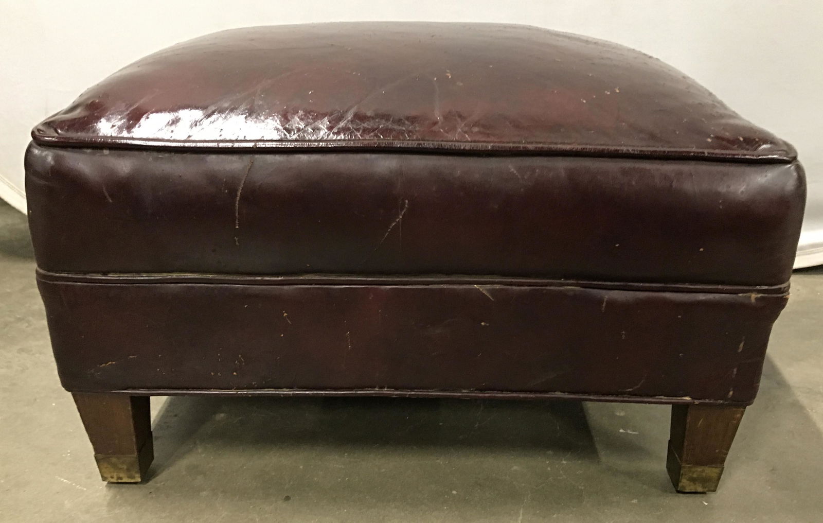 Vintage Leather Ottoman: Ottoman is mahogany toned, upholstered in leather. Feet are capped in brass. Ottoman, w&j sloane style ottoman, leather ottoman, living room furniture, home furnishings, hassock, seating bench, upcycl