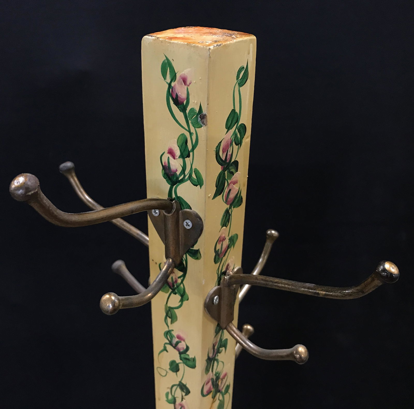 Vintage Hand Painted Wooden Coat Rack: Hand painted coat rack, vintage, possibly antique. Depicts flowering vines running along the center of each side, on a yellow base. Base of rack is colored emerald green. Measures approx 62.75 inches