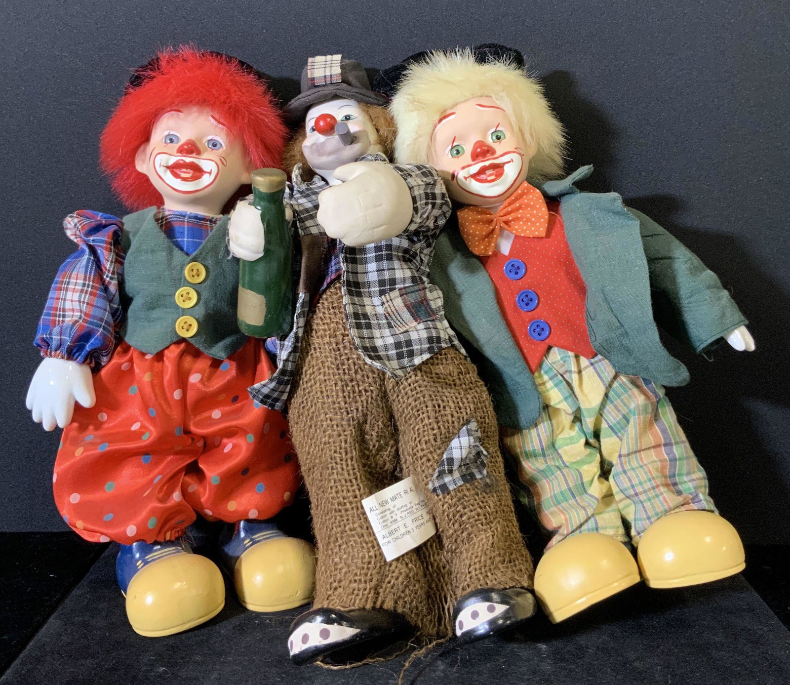 Lot 3 Hand Painted Porcelain Clown Dolls: Two clowns are matching, while the third has a different look. All clowns have white porcelain hands and faces. Hand painted faces. All clowns have the iconic large red nose and wear hats. Oversized p