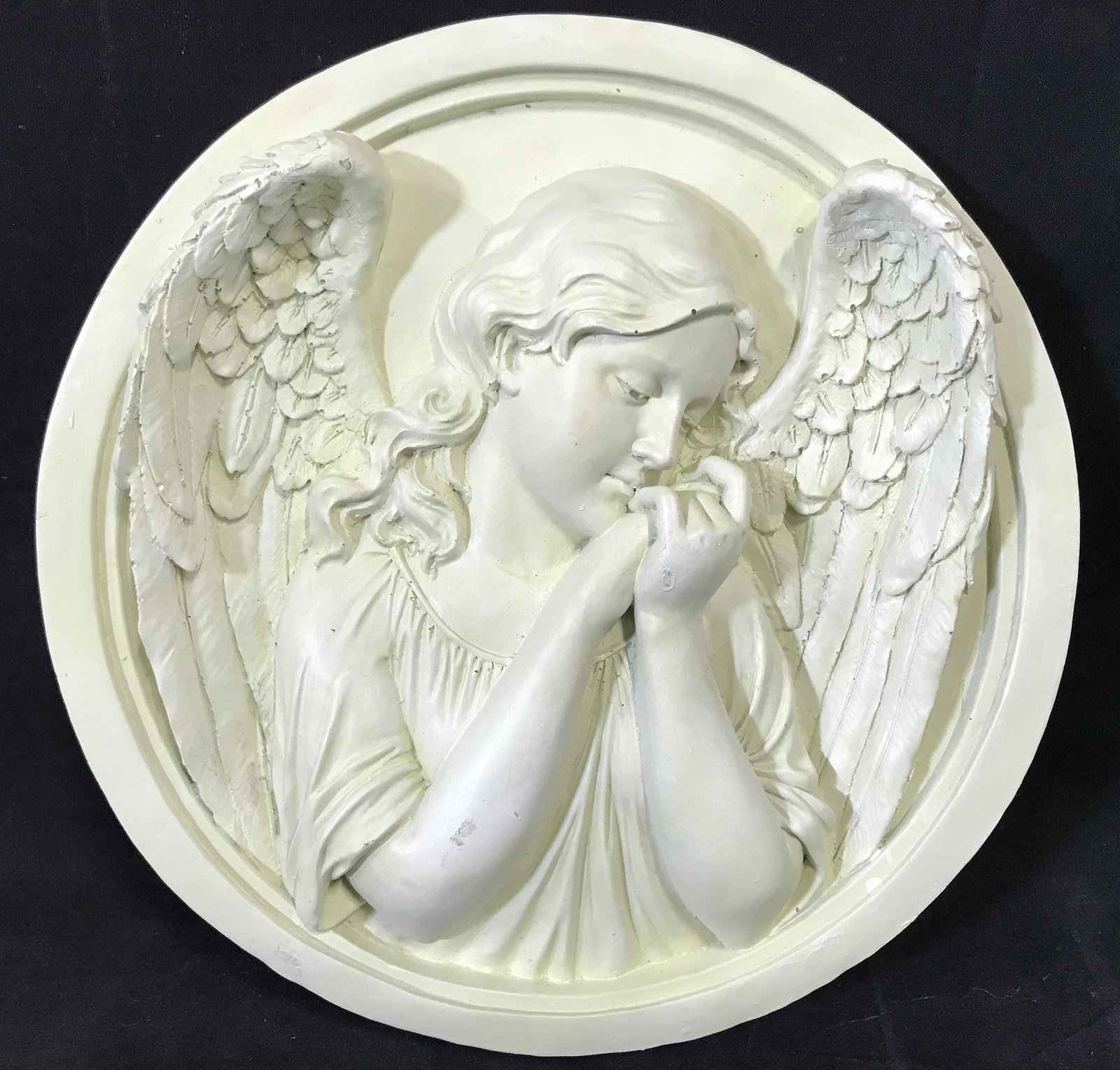 TOSCANO Composite Angel Plaque: Toscano Composite Angel Plaque, label to reverse reads ‘European Styled Sculpture hand crafted in China for Design Toscano’, subject a circular sculpture plaque of an angel with hands held togethe