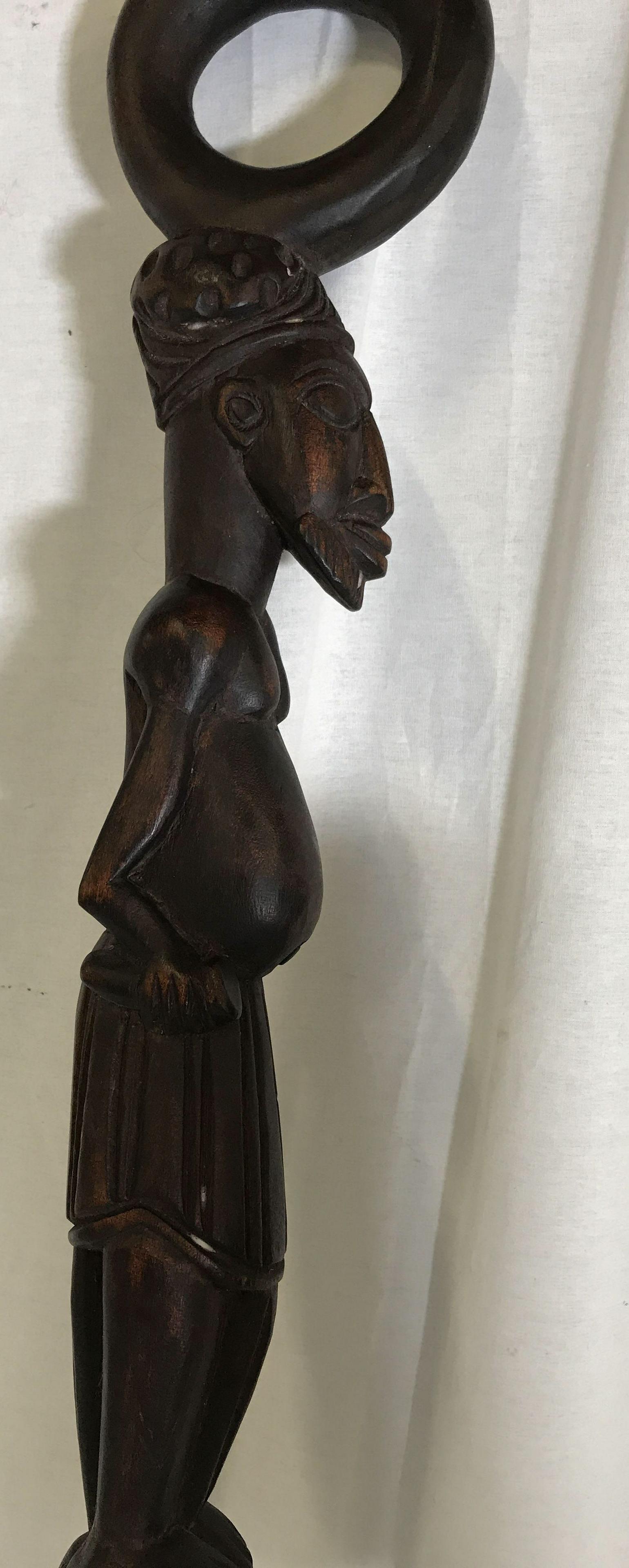 Cameroonian Bamileke Traditional Cane: Cameroonian Bamileke Traditional Cane, have origins in Western Cameroon Central Africa, carved from a single wooden block, stained in a dark brown pigment, handle of cane carved as a humanoid figure, 