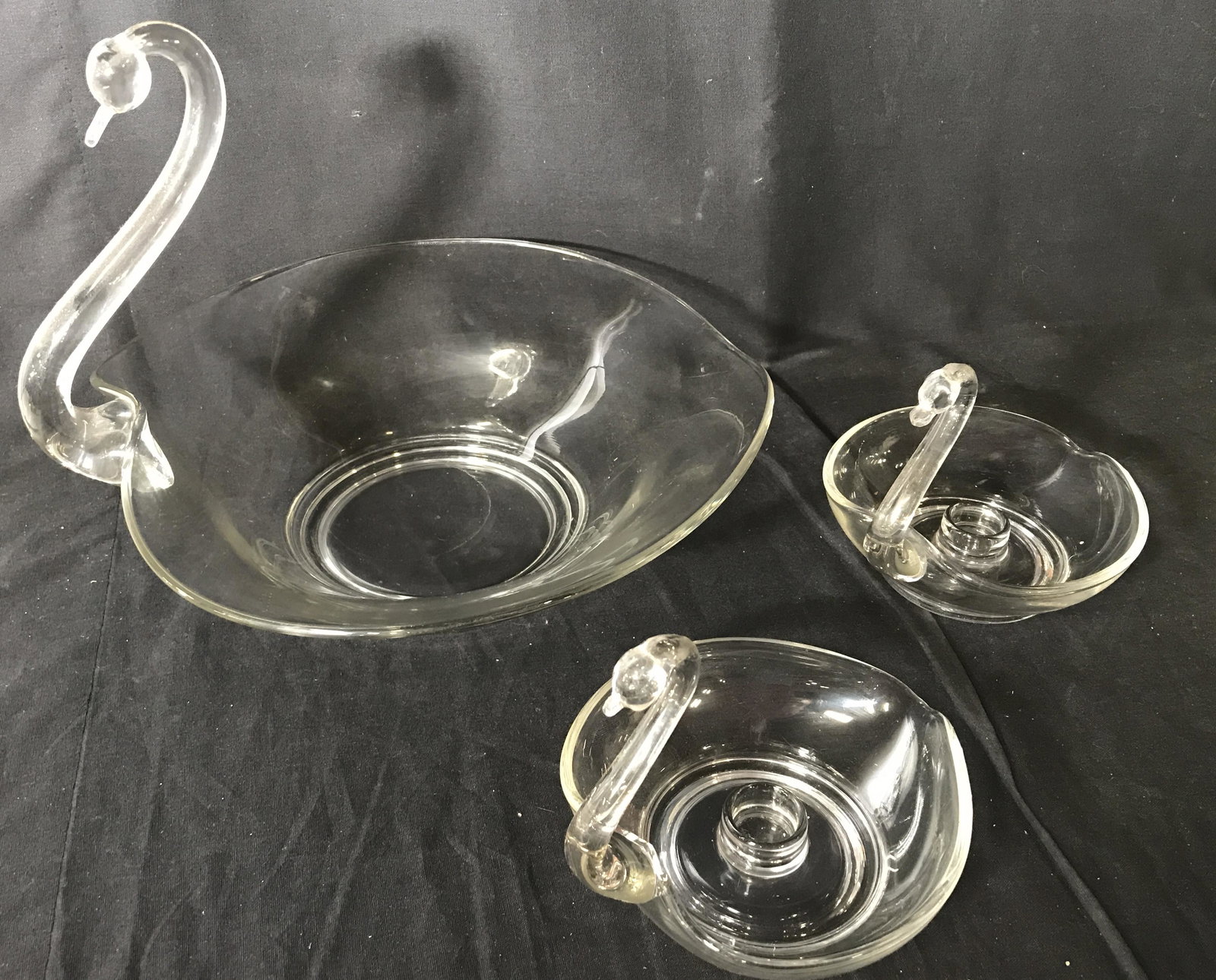 Set 3 Swan Form Glass Accessories: Includes two candlestick holders and a bowl. Each resembles a swan. The largest measures approx 9.5 inches H, and 12.5 inches W. Wear is consistent with age and use. Decorative bowl, zoomorphic, glass