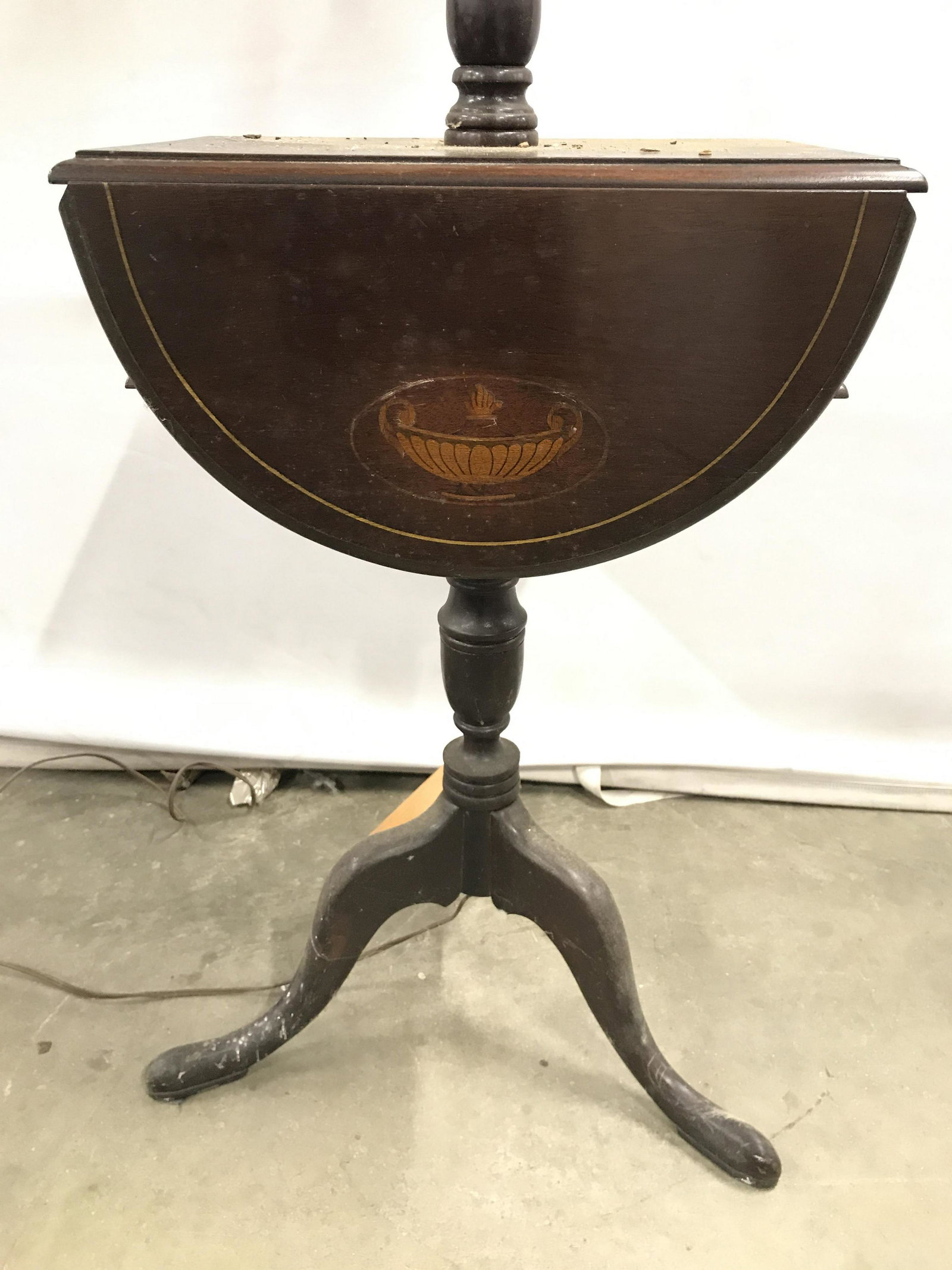 Vintage Drop Wooden Side Table Floor Lamp: Floor lamp is vintage and wooden. Piece has semi circle shaped drop leafs on side. Lamp has candlestick style fixture on top half including shade. Piece has tripod style legs. detail on Drop leafs are