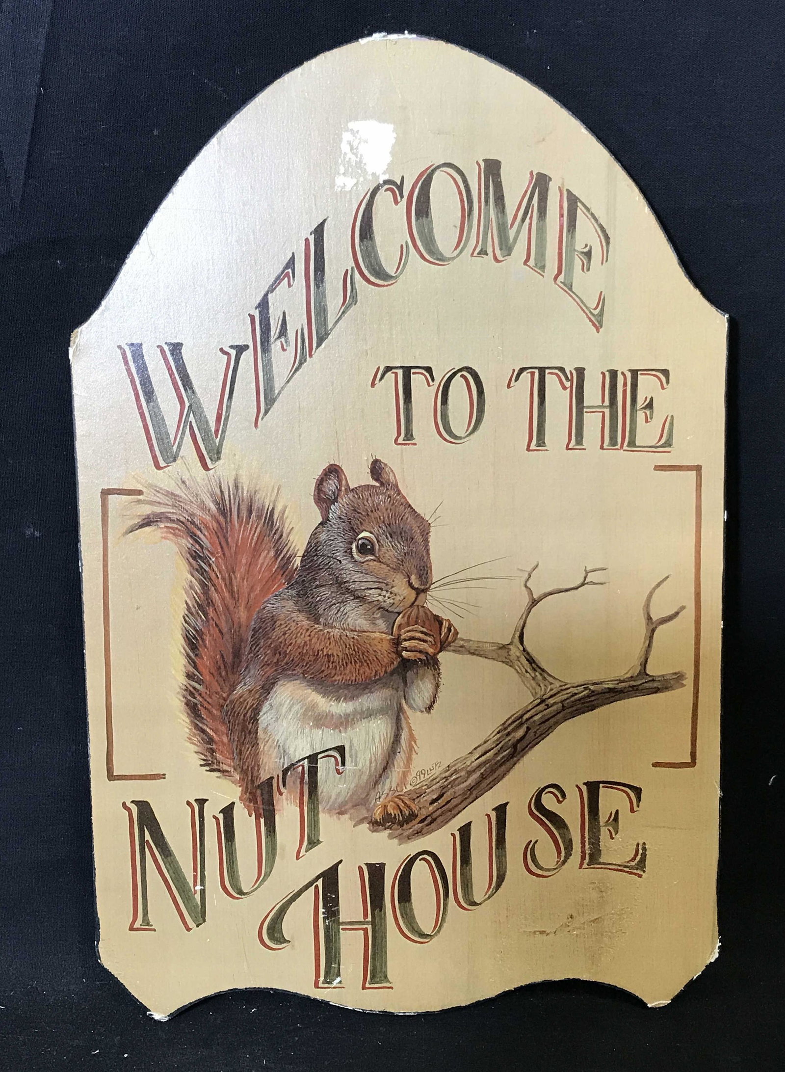 ASSCI Print on Wood Wall Art: ASSCI Print on Wood wall art, text to center of piece along tree branch reads ‘ASSCI 99 LUTZ’, stamp to reverse reads ‘Hand Crafted in USA By ASSCI’, subject a squirrel seated on a branch eati