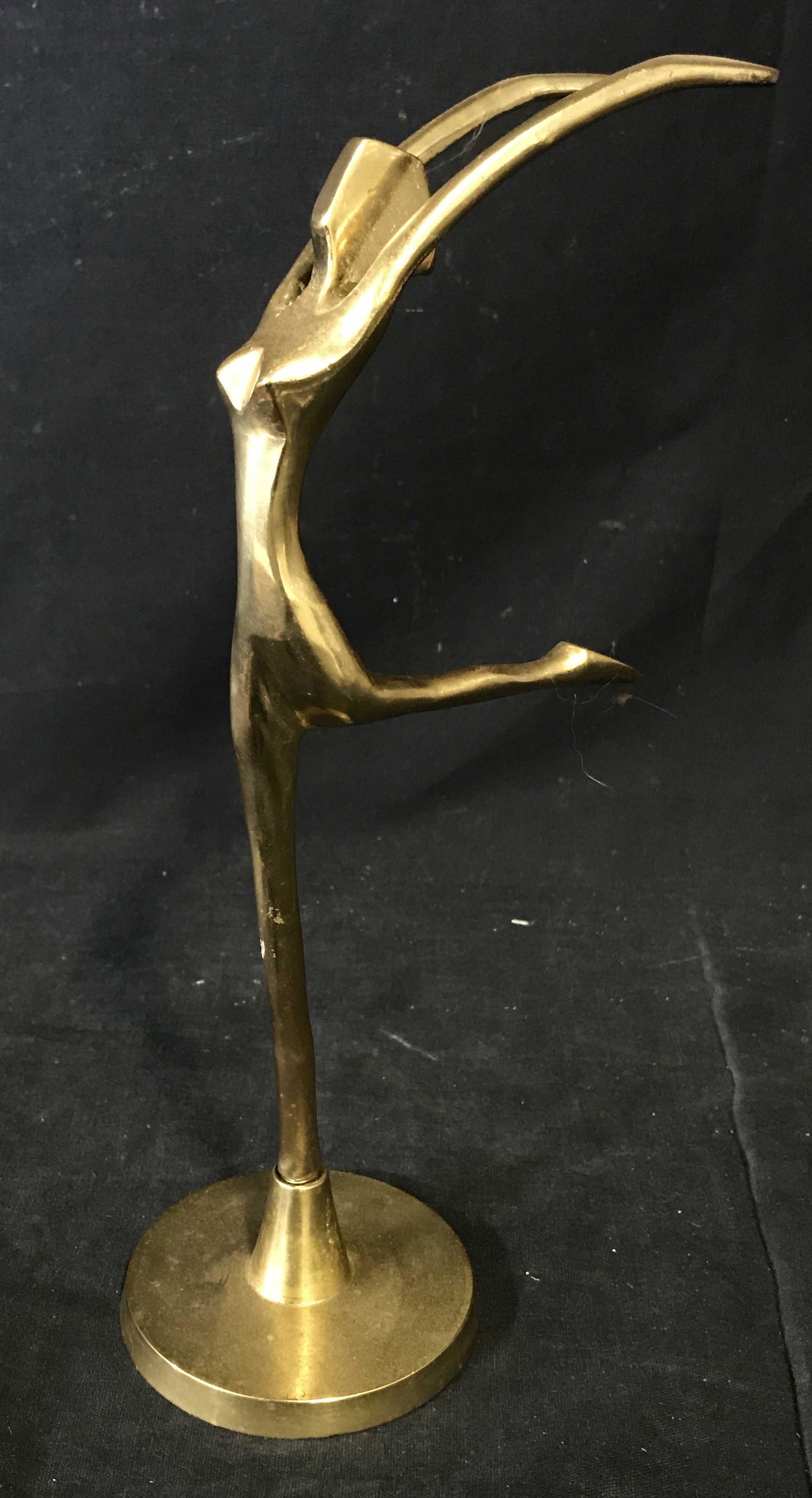 Gold Toned Metal Art Deco Figural Sculpture: Gold toned metal Art Deco Figural sculpture, no apparent signatures or stamps, subject a minimalist female figure mid leap with one leg back and arms thrown above her head, piece screwed into platform