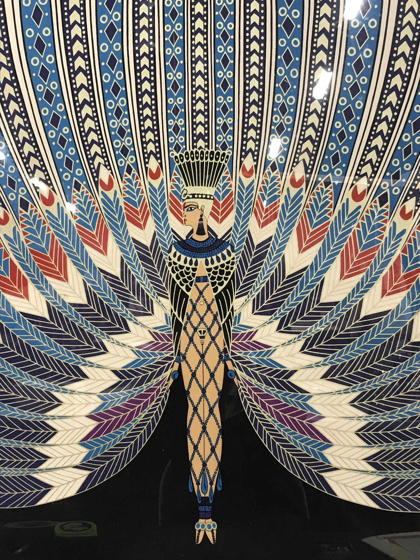 Framed Signed ERTE Fabric Artwork: Framed signed fabric, signature in the lower right corner possibly reads ‘ERTE’, subject depicts a female figure in EgyptIan garb with an array of feathers around her, black and gold composite fra