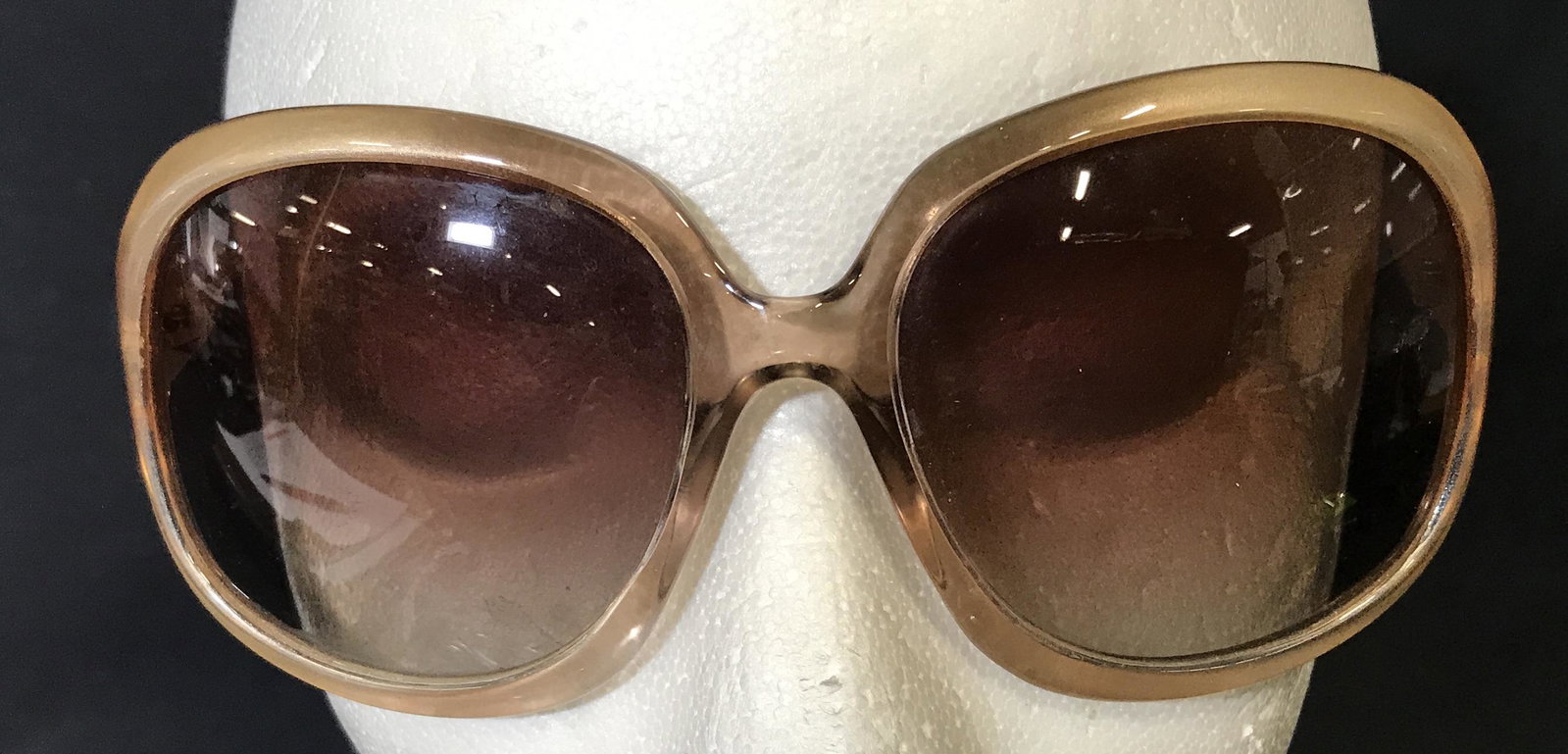 2 Pairs of Sunglasses, Italy Designs and more: 2 pairs of sunglasses, one of the two has a label that reads ‘Italy Design 3113 69016-135’, the larger of the two is metallic tan colored with large lenses and a solid composite body, smaller of t