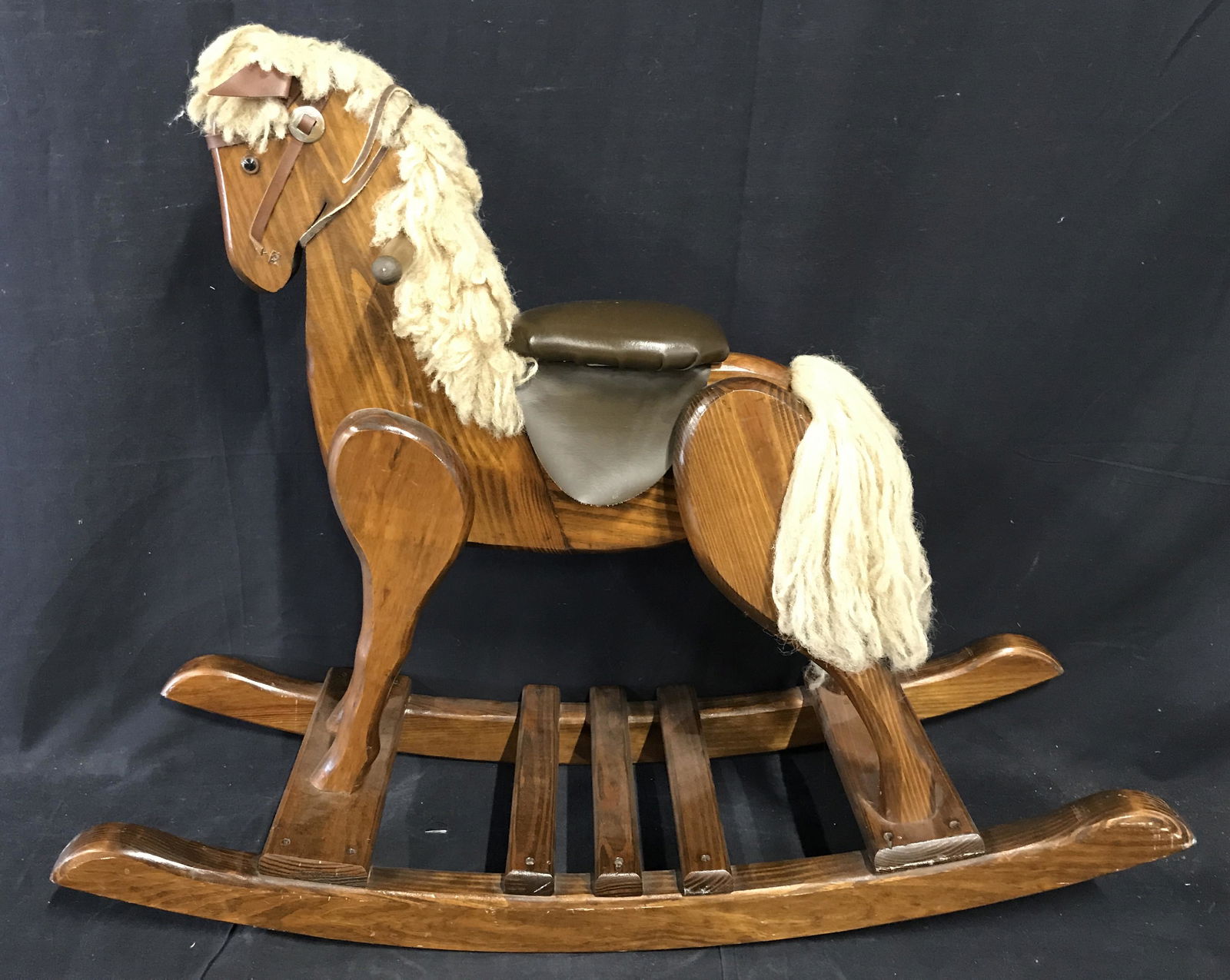 Wooden Rocking Horse: Possibly Vintage wooden rocking horse, no apparent stamps or labels, piece made entirely of a dark brown stained and polished wood with accents of yarn leather and silver toned metal, scratches to woo