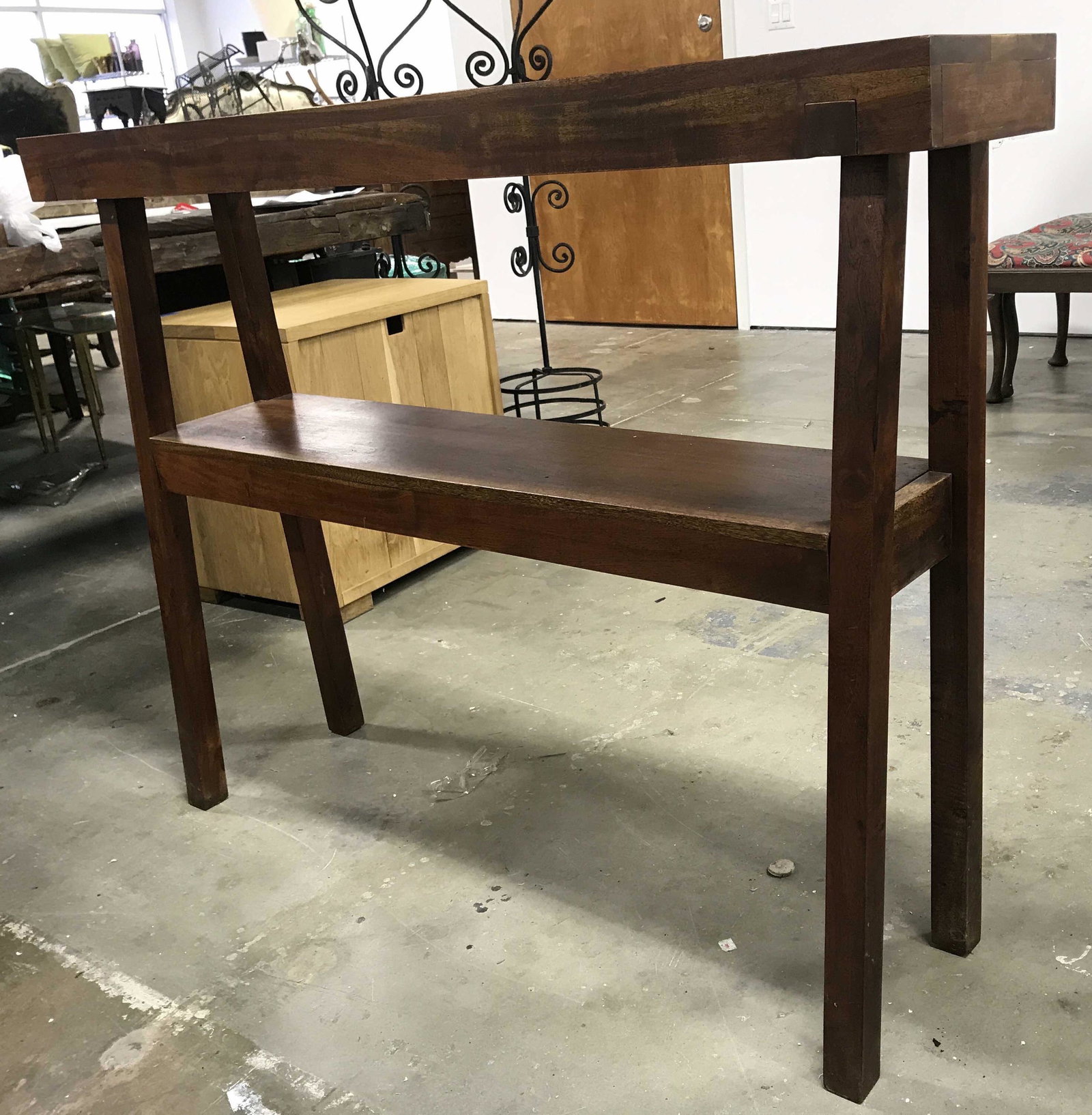WEST ELM Carved Wooden Console Table: Underside of tabletop has label which reads WEST ELM. Table has shelf underneath tabletop. Piece is wooden, possibly hand crafted. Piece measures approximately 48 inches long 36 inches tall 10 inches 
