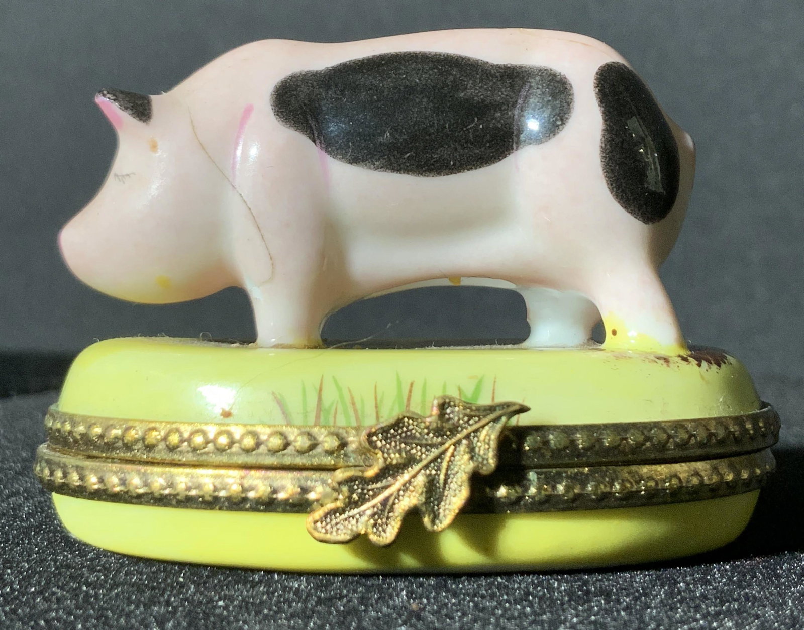 LIMOGES Vin. French Porcelain Pig Figural Pill Box: Vintage French porcelain pig Figural pill box. Hand painted designs on the box and on the pig. Pig is pink with black spots. The pig stands on the lid in a painted mud puddle. Grass along the sides, b