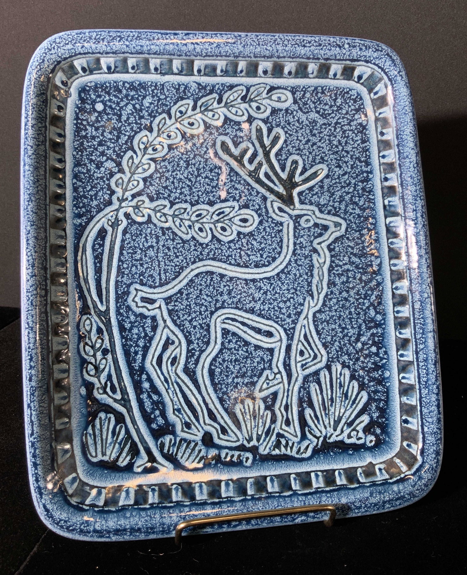 ELLEN NORHAY Signed Vintage Artisan Ceramic Plate: A artisan ceramic plate with hand painted deer motif in the center. Glazed blue. The boarder surrounding the deer is in relief of the plate. Underside signed by artist, reads: 515 Ellen Norhay. Pittin