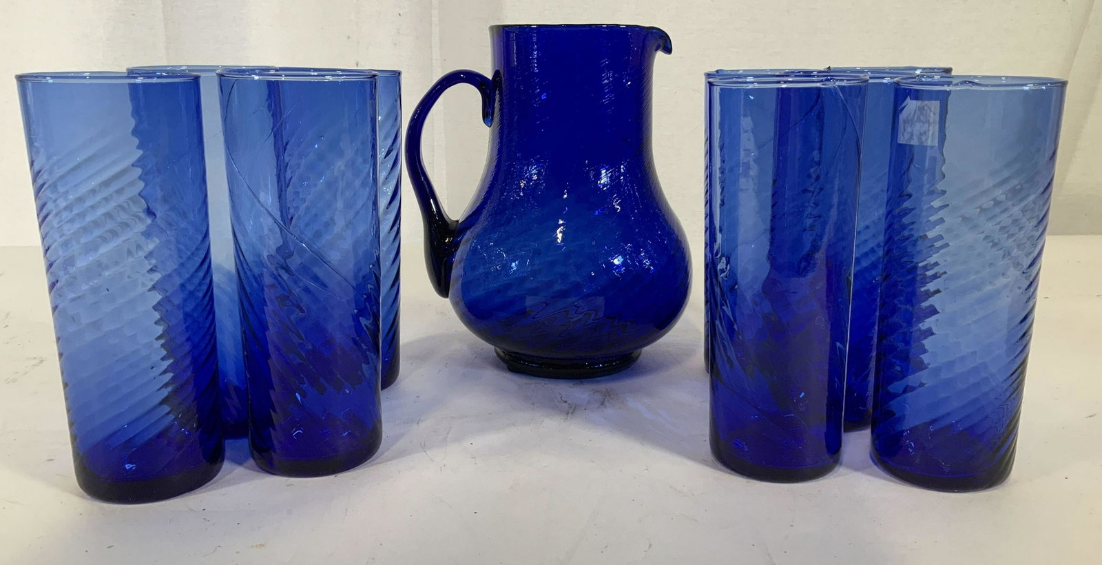 Cobalt Blue Pitcher Glass Bar Set, 10 pcs: 9 tall glasses and 1 pitcher, hand formed cobalt blue blue glass set with swirl pattern, pitcher measures ht 8 inches, cylindrical high boy or iced tea glasses measure ht app 7 inches, bar ware, table