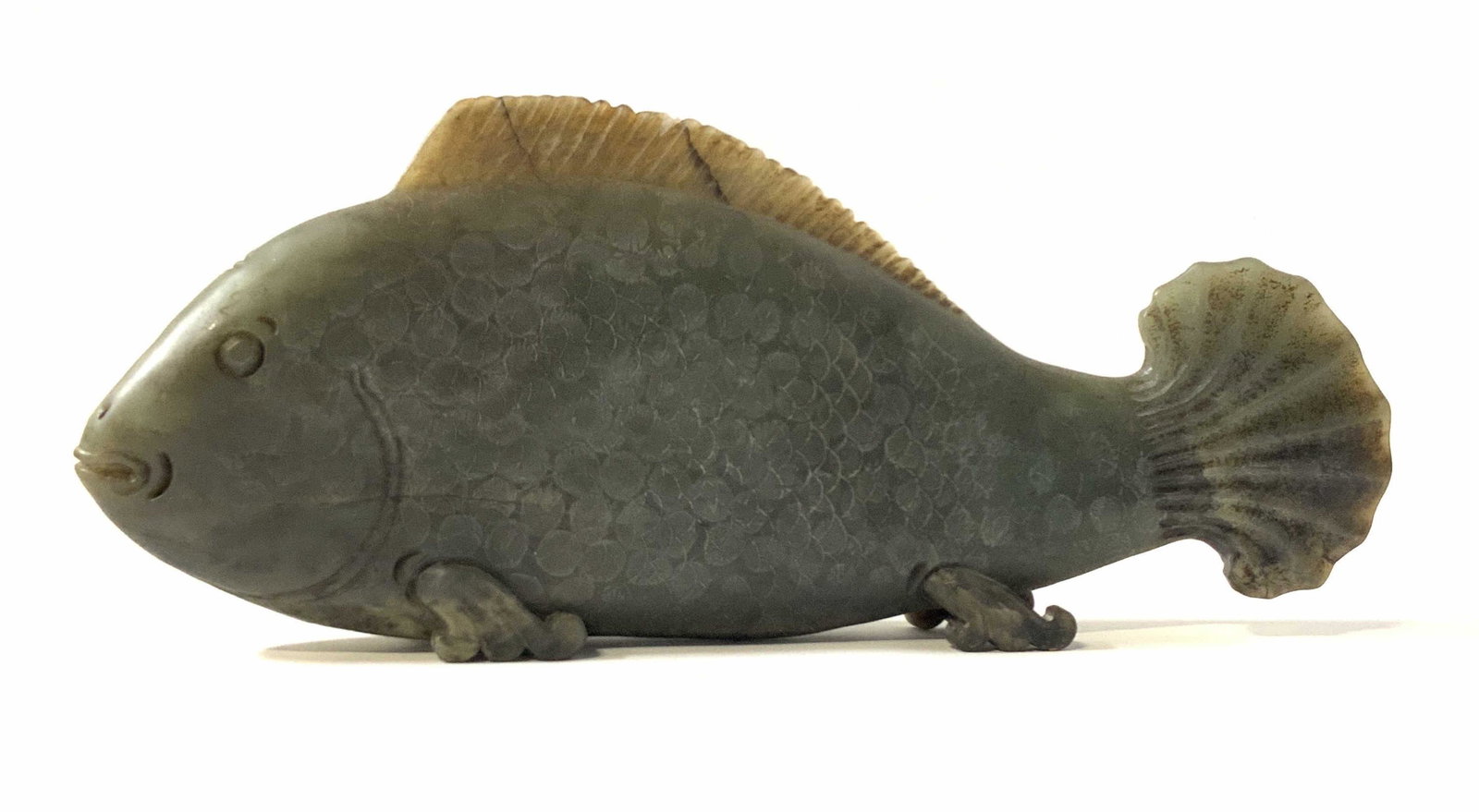 Vintage Asian Jade Standing Fish Carving: Vintage, possibly antique, deep green jade fish carving. The fish stands on its own with 4 intricately carved fin / feet. Dark green color with splashes of white and light green hues. One mild chip to