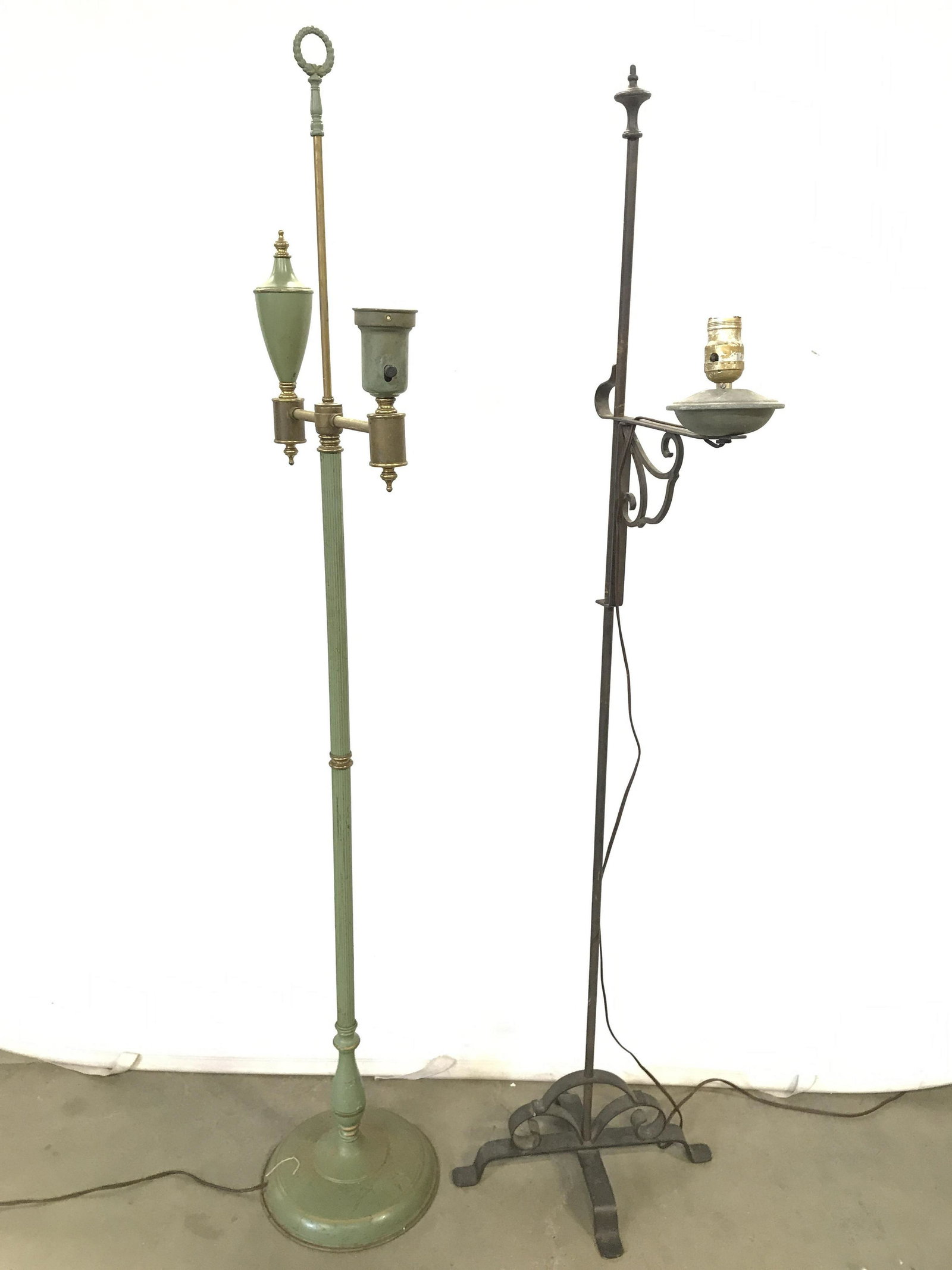 Lot 2 Antique Toleware Floor Lamps: Lamps are vintage possibly antique. Lot includes 2 metal Toleware floor lamps. One lamp is green toned while the other is black. Base of green lamp is circular shaped. Black toned lamp has 4 feet. Pro