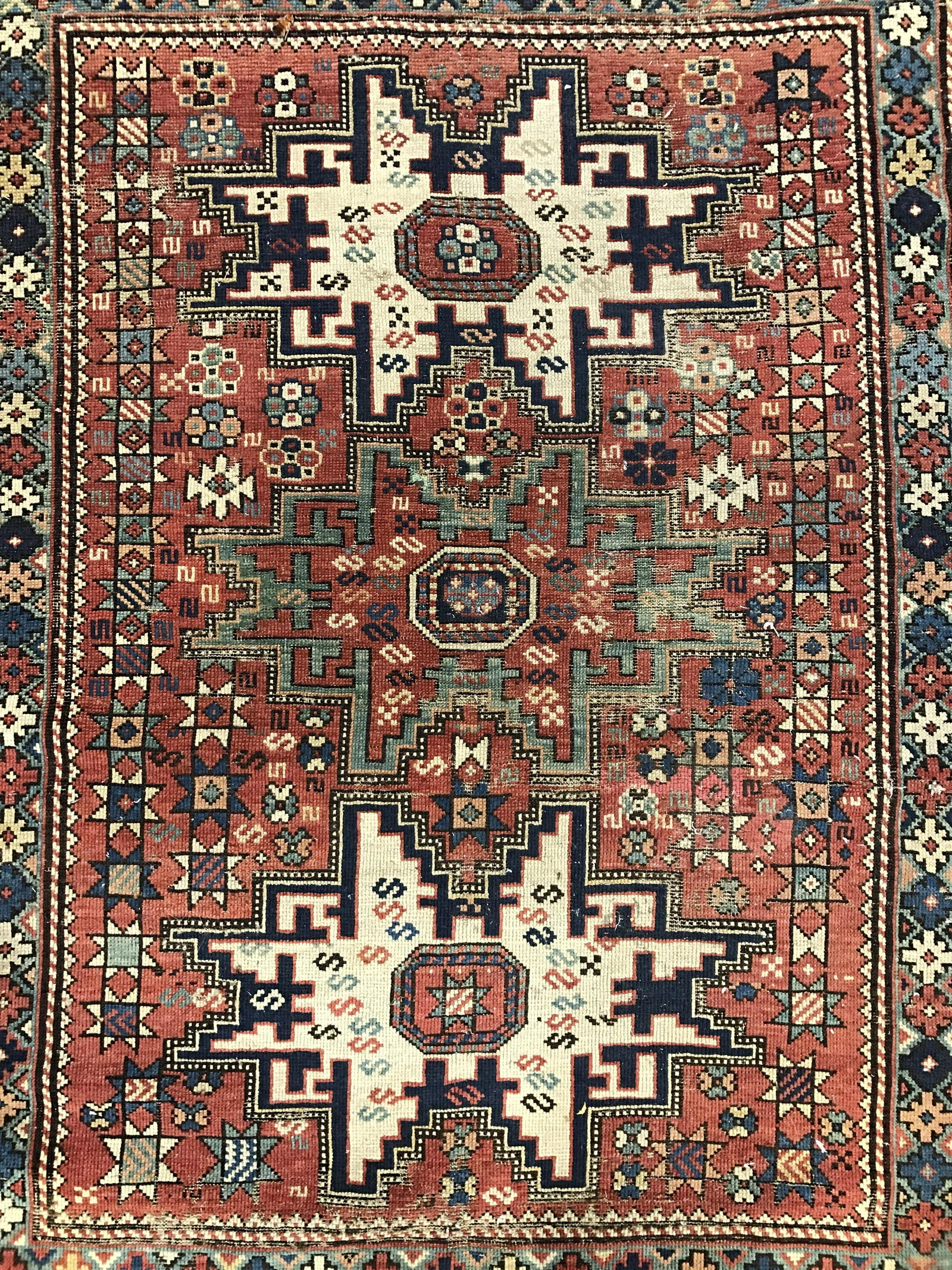 Antique Handmade Fringed Turkish Wool Rug: Rug is wool and handmade. Piece is vintage possibly antique. Rug appears to be Turkish. Piece contains intricate multi toned geometric detail. Rug has very small fringes. Piece measures approximately 