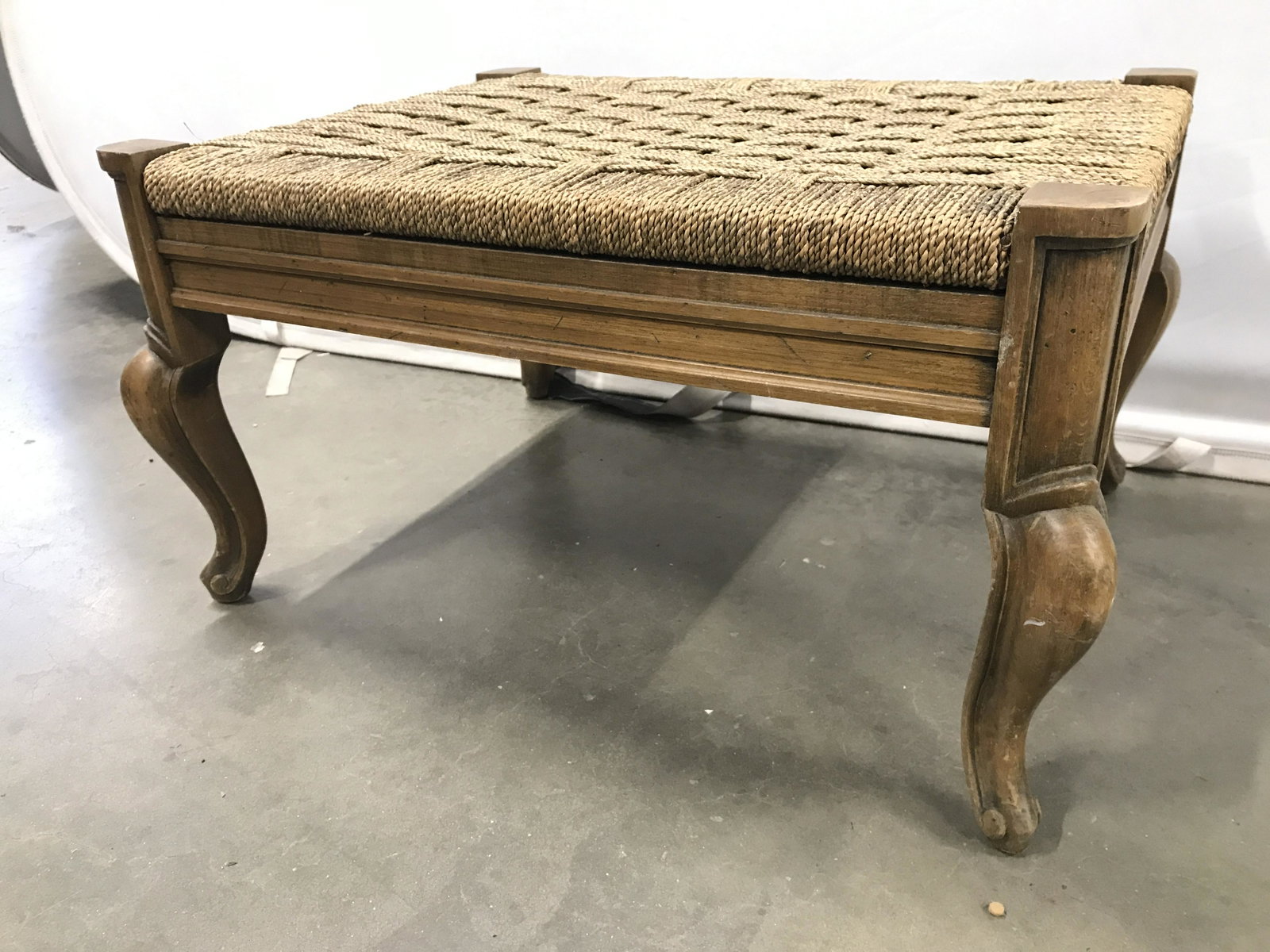 Vintage Carved Wooden Woven Top Footstool: Footstool is vintage wooden. Top of piece has woven structure. Piece has short cabriole style legs. Piece measures approximately 26 inches long 20 inches deep 13 inches tall Stool, footstool, wooden f