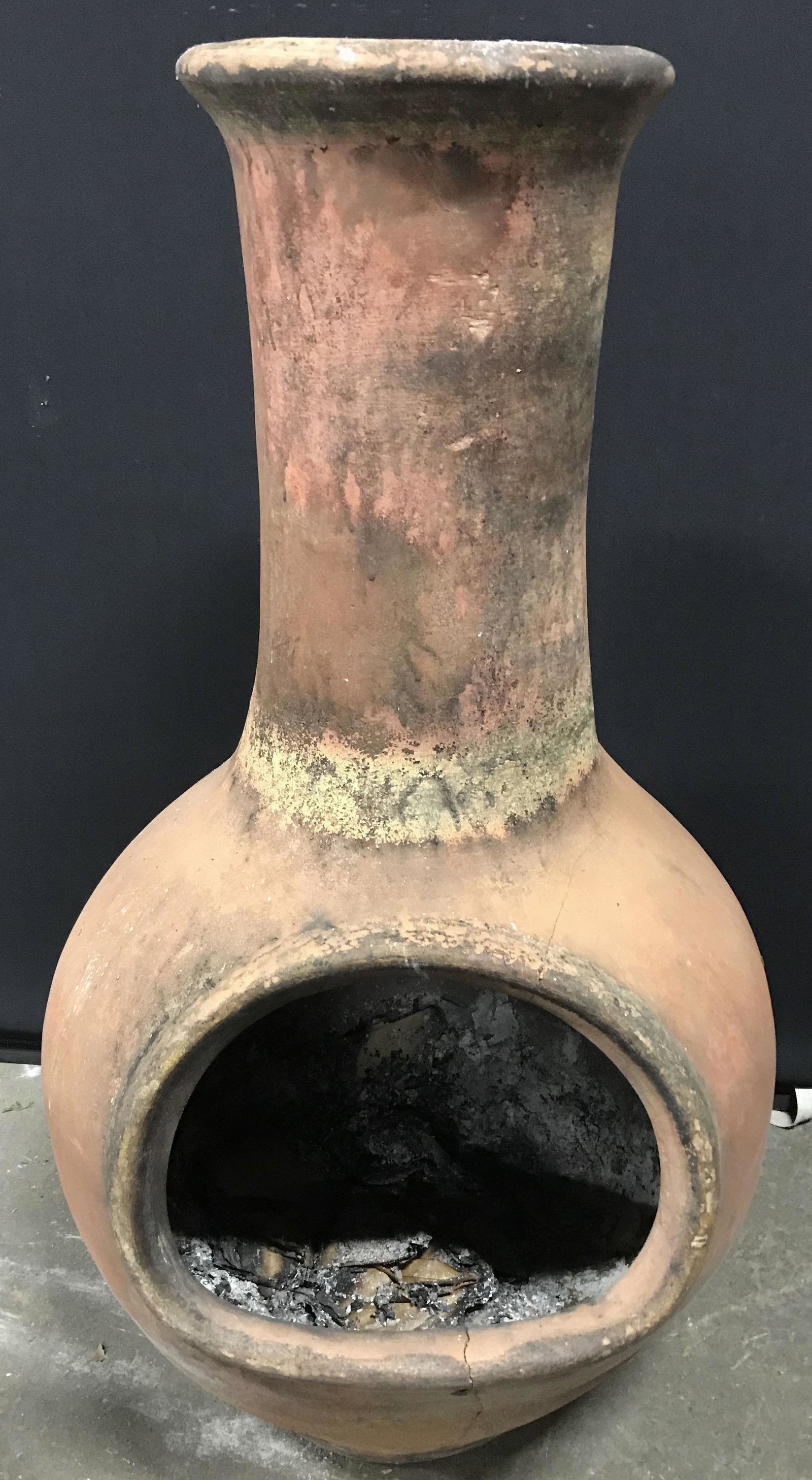 Vintage Earthenware Chiminea: Vintage earthenware chiminea. Measures approx 37.5 inches H, and 21 inches W. Wear is consistent with age and use. Cracking along the front is present. Property of Janine Metz estate, social secretary