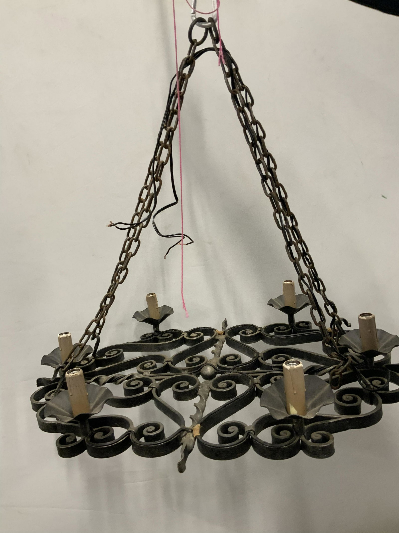 Vintage Iron Chandelier: Vintage, possibly antique, chandelier. Crafted from iron, sockets resemble melting candles. Four chains converge and support the chandelier. Measures approx 30 inches H, and 29 inches W. Wear is consi
