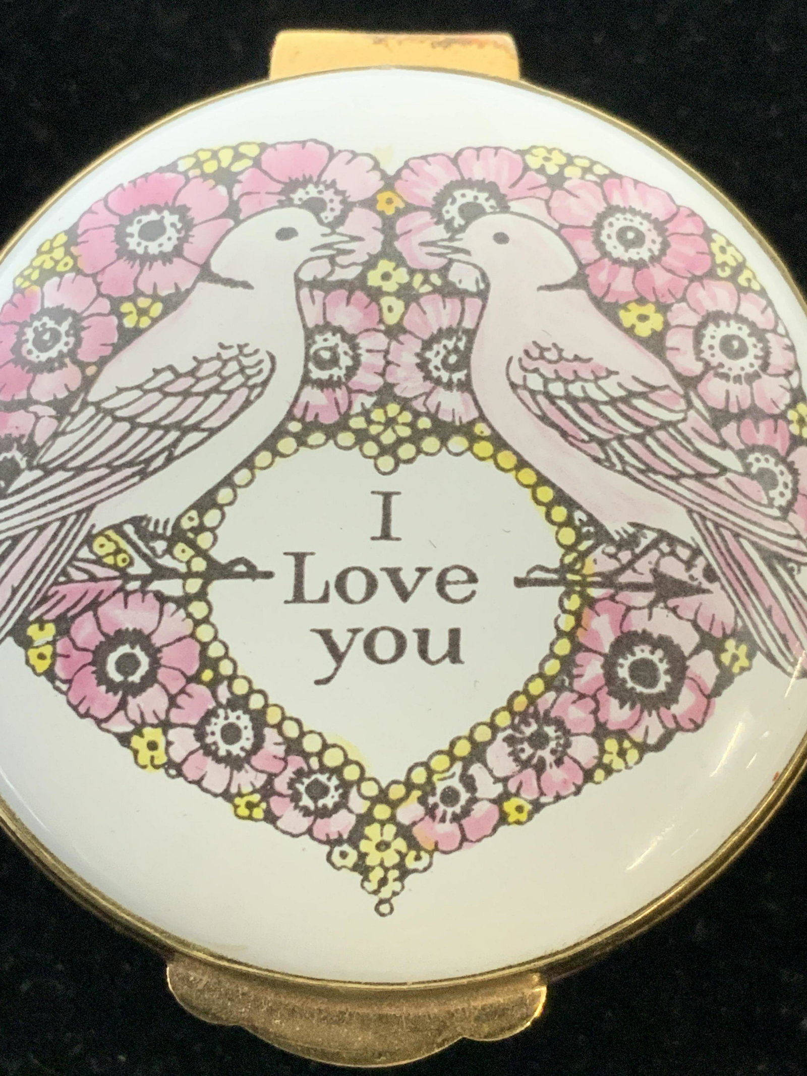 CRUMMLESS & CO Enamel Dove Motif Pill Box, England: Pink & White metal box with kissing dove birds within a floral heart. Inscription’ I Love You’ . Verso Hallmarked ‘ Made In England by Crummles & Co’. 1.5 in. W, 1 in. Ht. Made in England, Hal