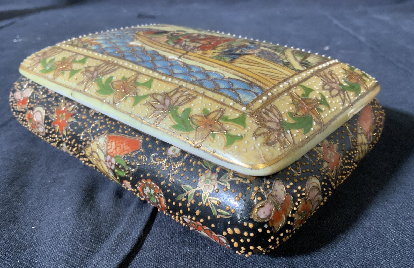 Vintage Hand Painted Porcelain Keepsake Box: Trinket box is vintage and has hand painted elements. Piece has intricate geometric detail and depiction of figures sailing in a body of water on lid. Piece measures approx 6.5 inches wide 5.5 inches 