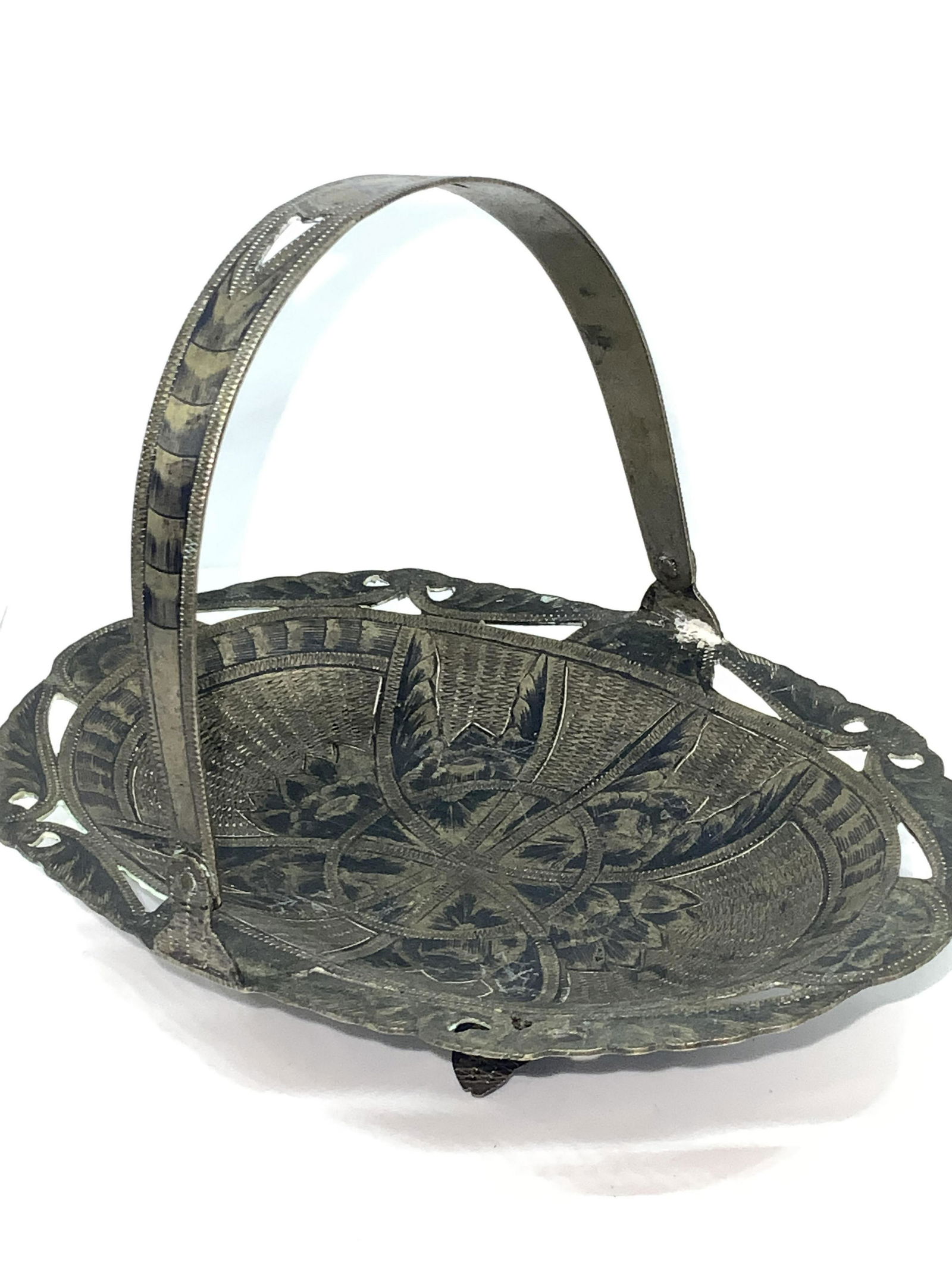 Pair Vintage Silver Middle Eastern Candy Dishes: A pair of vintage, possibly antique, Middle Eastern candy dishes. Each dish features etched and pierced metal designs. Designs depict floral and geometric patterns. Each dish has four feet on the unde