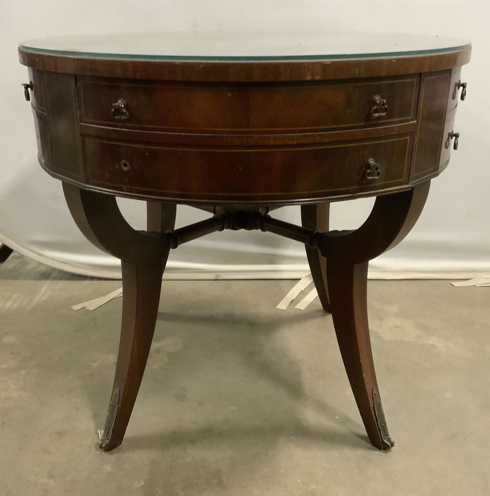 Vntg Round Wooden Glass Top Side Table W Drawer: Side table is vintage possibly antique. Piece has 1 drawer with 4 small dangling metal handles. Tabletop appears to be leather top with glass top sitting on top. Leather top has gold toned ornate deta