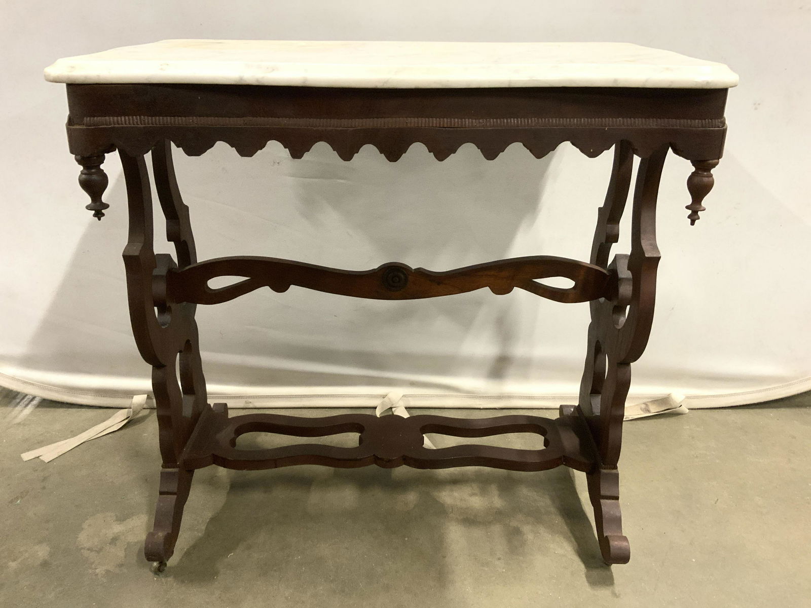Vntg Wood Victorian Style Side Table W Marble Top: Table is vintage possibly antique. Piece has intricately carved wooden detail. Piece sits on 4 casters. Table top is marble with various tones of cream & slate. Piece measures approx 29 inches tall 28