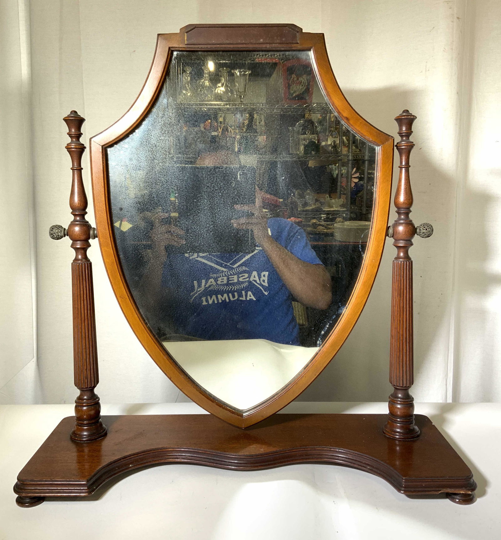 Antique Victorian Wooden Dressing Table Mirror: Dressing table mirror has wooden frame, base, & supports. Base of mirror is footed. Mirror has victorian style. Mirror shape resembles shield. Measures approx 25 inches tall 24 inches wide 9 inches de
