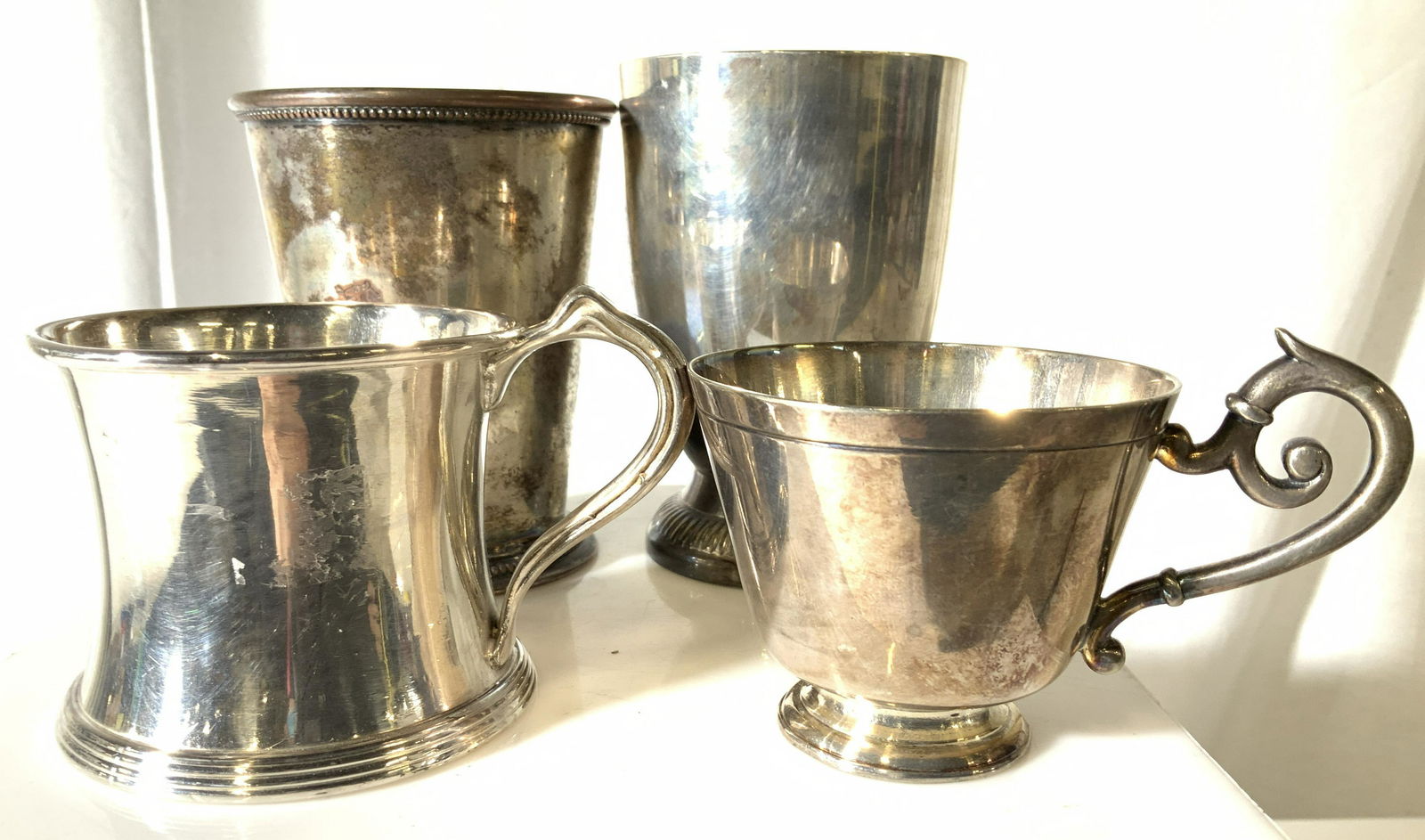 Grp 4 Silver Plated Exeter Julie Cup, more: child’s silver plated cup with handle. One Hallmarked Wallace Bro Silver Co V527 , weighted piece with good shine. Other cup has more of a tea cup shape with more ornate handle, underside reads ‘