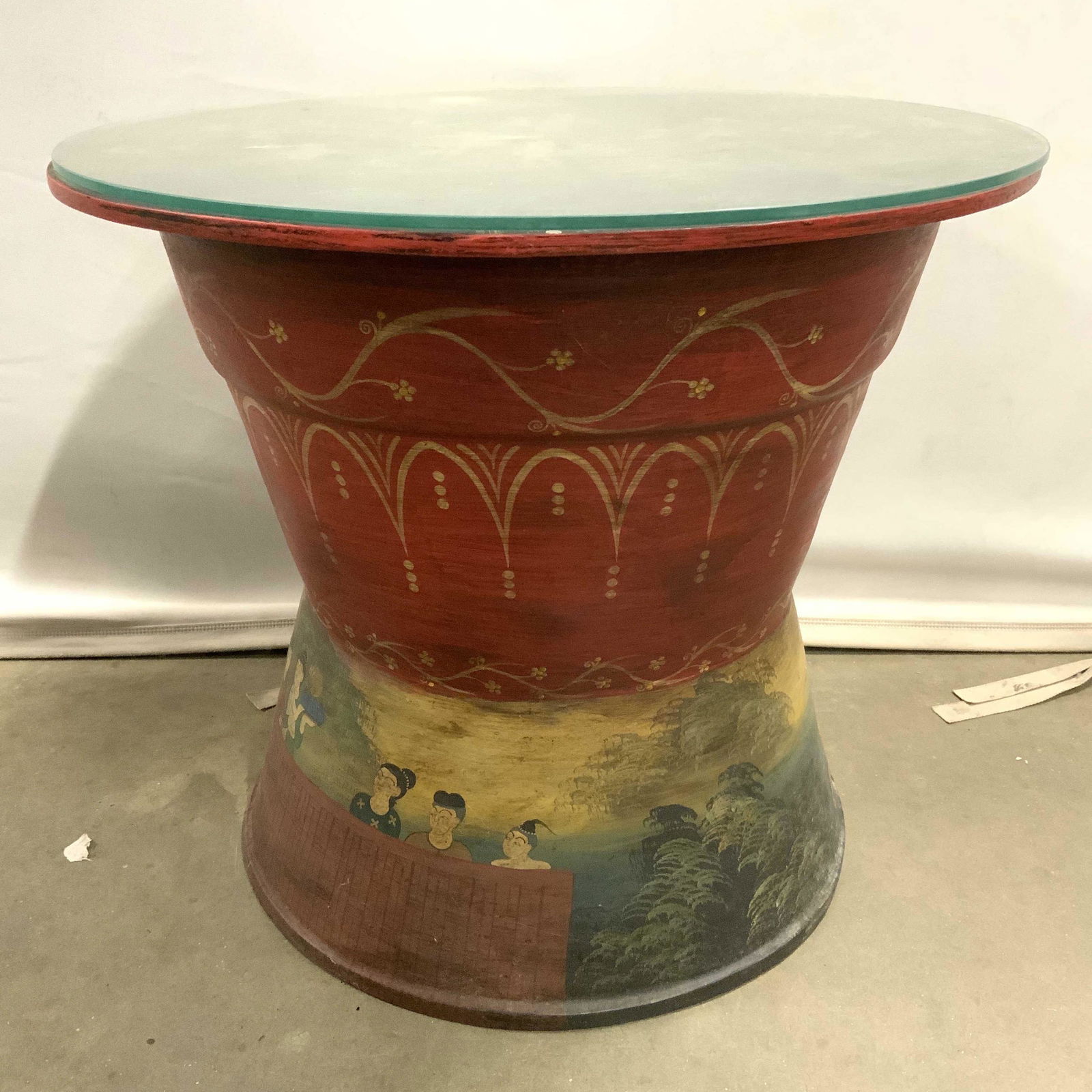 Vintage Tibetan Hand Painted Side Table: Side table is vintage possibly antique. Side table has round glass top. Piece appears to be Tibetan with hand painted detail depicting multiple figures in a village. Property of Janine Metz Social Sec