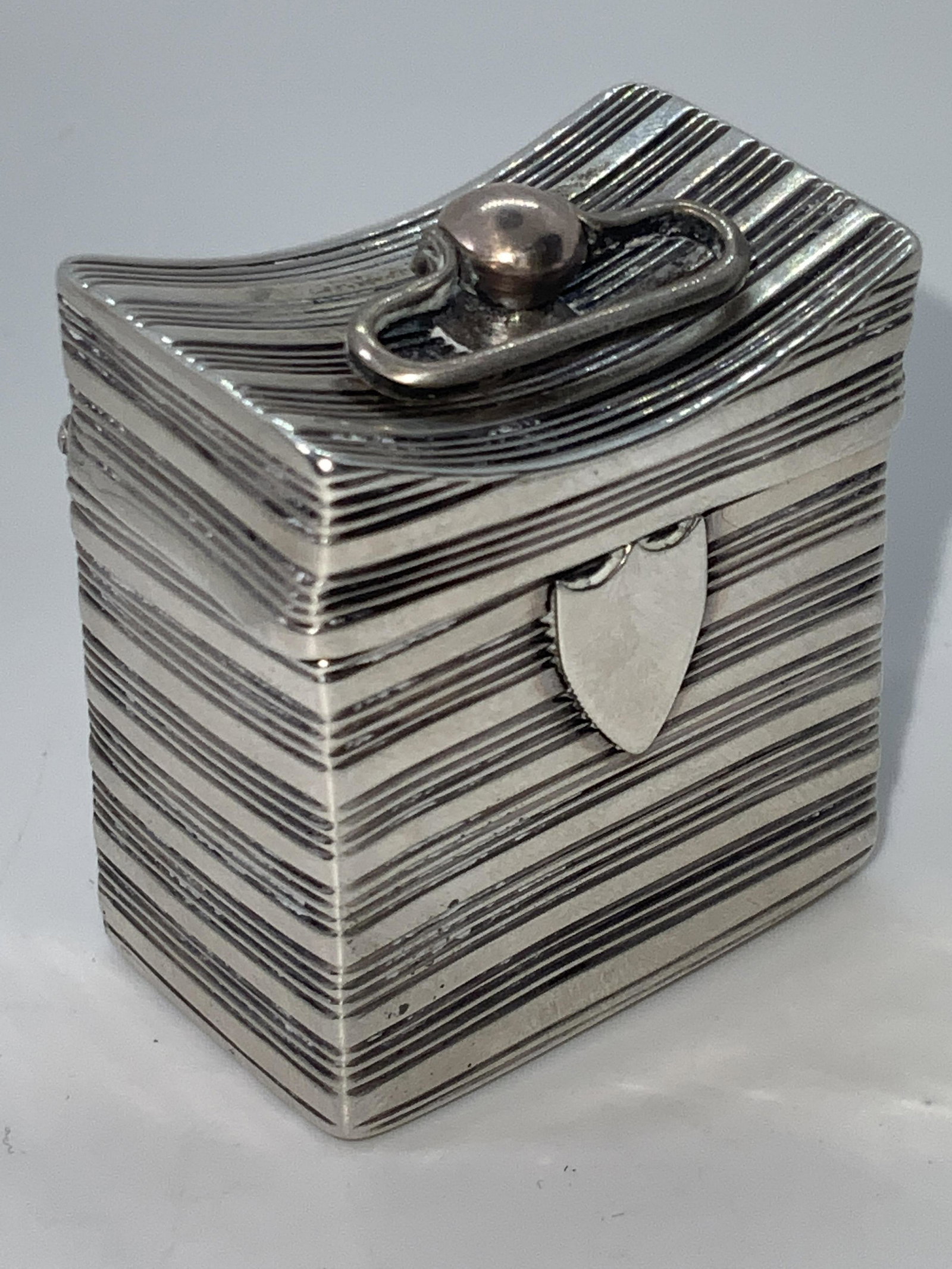 Antique Dutch Sterling Silver Hinged Pill Box: An antique (circa 1835) Dutch sterling silver pill box. This hinged pill box also features a small handle connected to the top. The handle is attached to where the pill box decoratively dips. Exterior