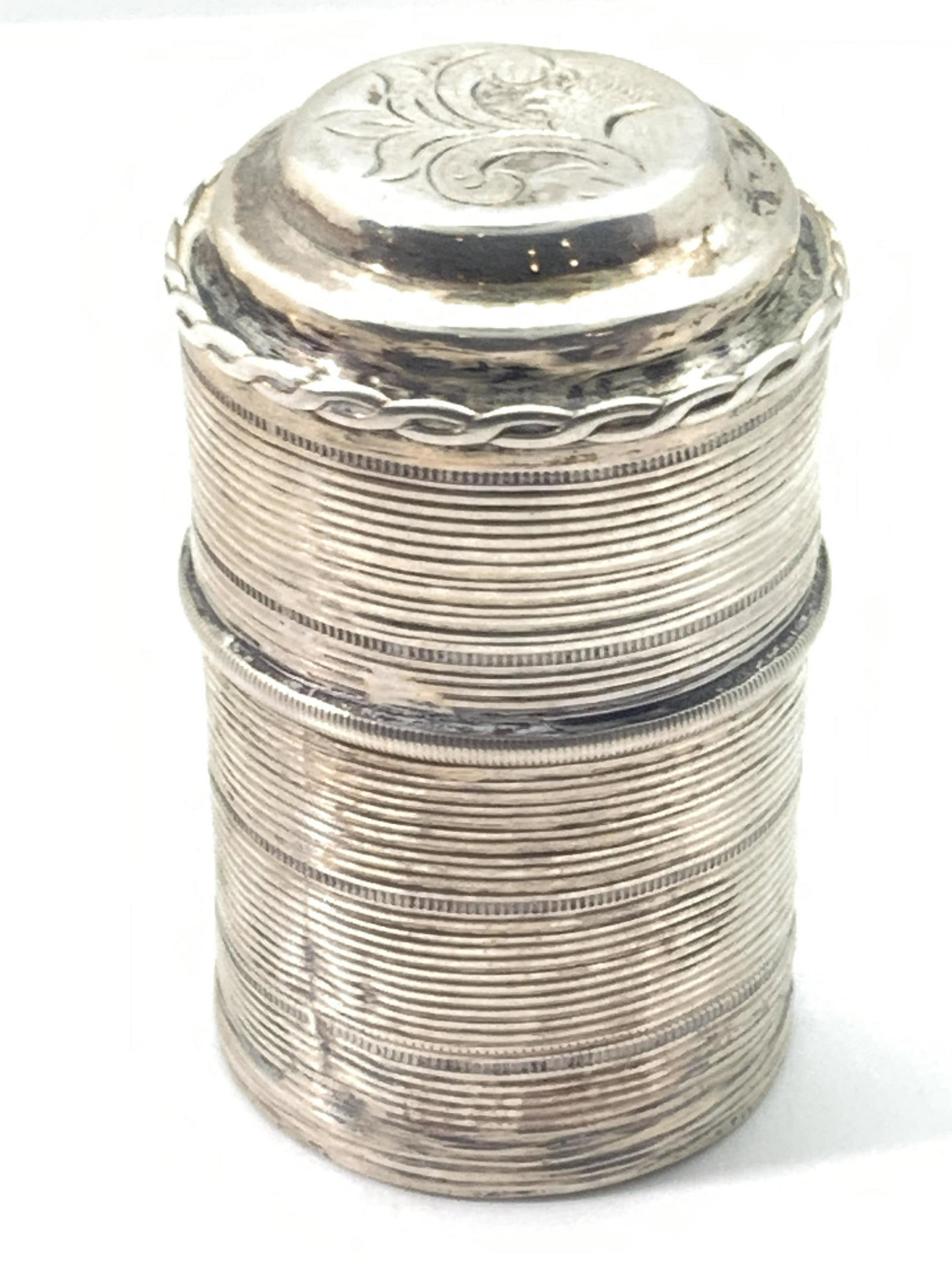 Antique Dutch Sterling Silver Crest Pill Box: An antique (circa 1873) Dutch sterling silver pill box. This piece is fitted with a lid that fits to the base seamlessly. Exterior detailing features horizontal etched, uniform bands all along the pie