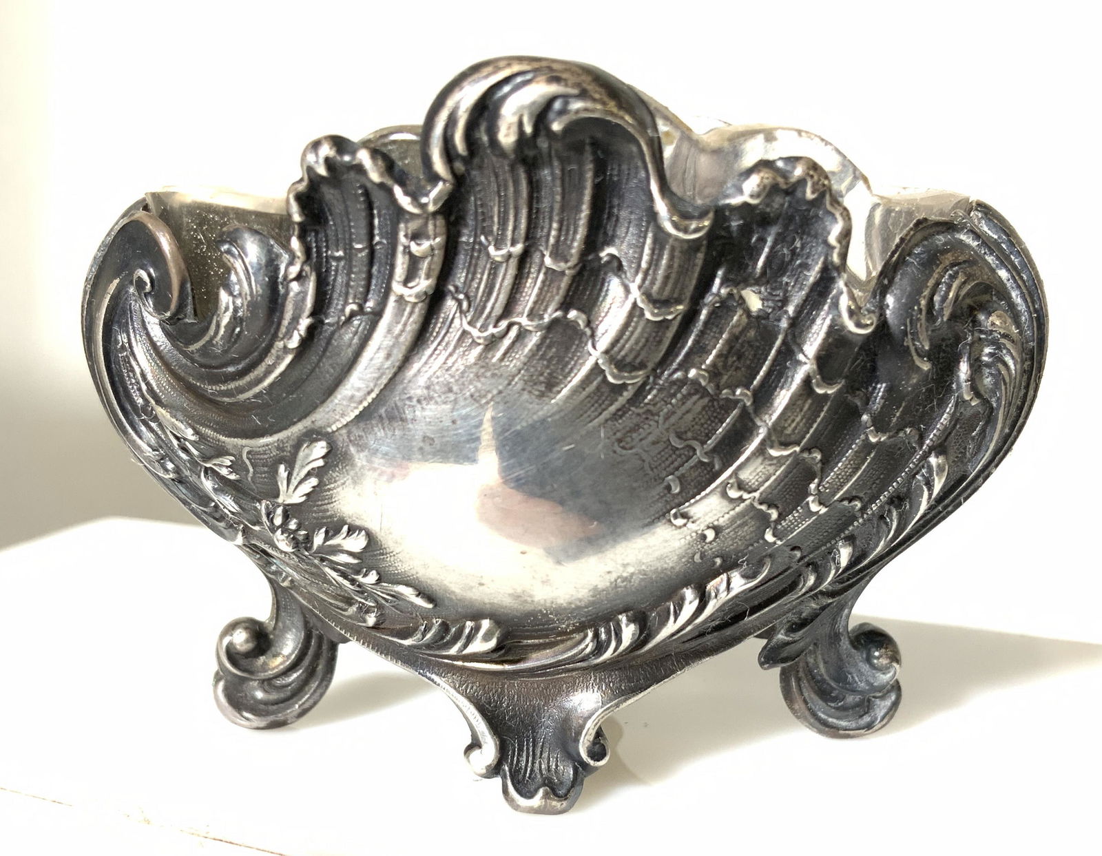 ANTIQUE STERLING SILVER NOUVEAU Table Accessory: sterling silver salt cellar in shell form, chased silver art nouveau, scrolled feet. Glass insert comes out. Piece not Hallmarked. tested + for silver with puriTEST KIT . .54 ozt silver only. 2.5 in.