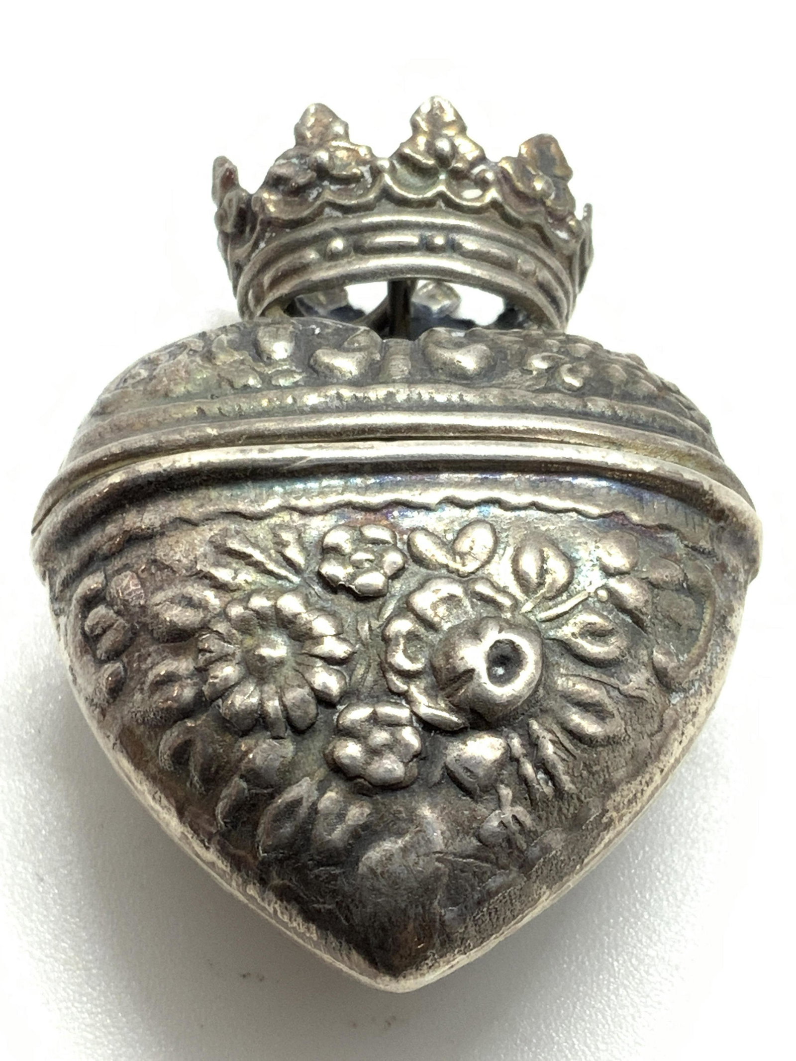 Antique Victorian S. Silver Heart Locket Pendant: An antique Victorian sterling silver locket pendant in the form of a heart. The locket has embossed floral detailing all along the heart. Above & affixed to the heart form is an embossed crown. Attach