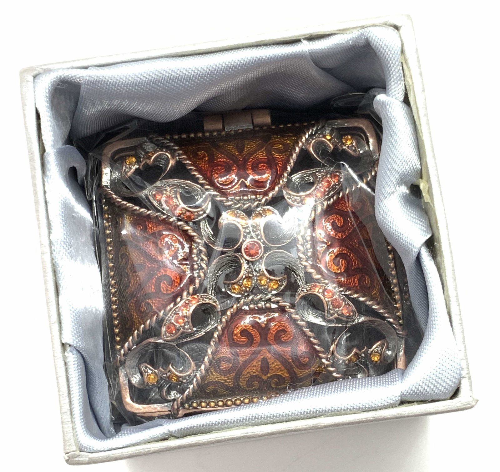 BEJEWELED ASIAN TRINKET BOX, New in Package: A metal trinket box decorated with rhinestones and enamelwork. Pierced, in relief metalwork decorates the lid of the trinket box. It opens and closes with hinge hardware. The enamelwork and the rhines