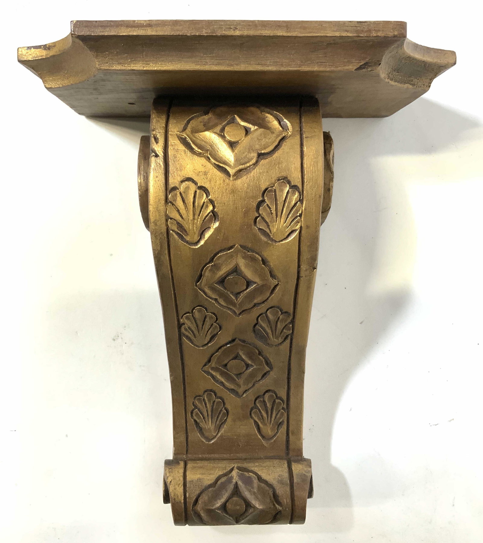 Vintage Carved Wooden Gold Lead Wall Shelf: Wall shelf is vintage possibly antique. Piece has gold leaf layer. Shelf support has s scroll structure and shell & geometric detail in relief. Piece measures approx 8.5 inches tall 7 inches wide 4 in