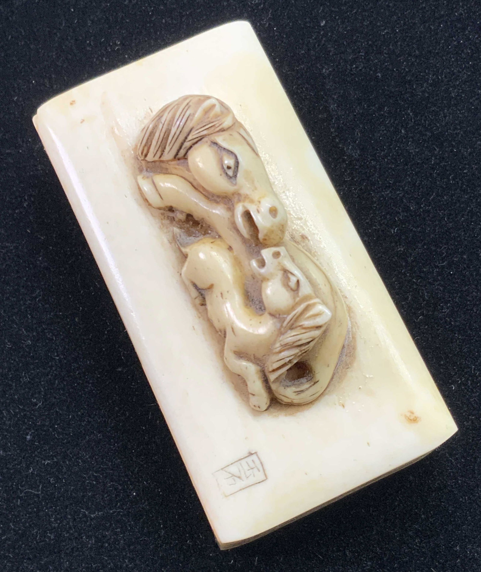 ASIAN CARVED ANTQ SIGN HORSE SNUFF BOX: A vintage, possibly antique, precisely incised Asian snuff box depicting two horses on the lid. This collectible piece is crafted from bone and features etched foliage along all sides, and two carved 