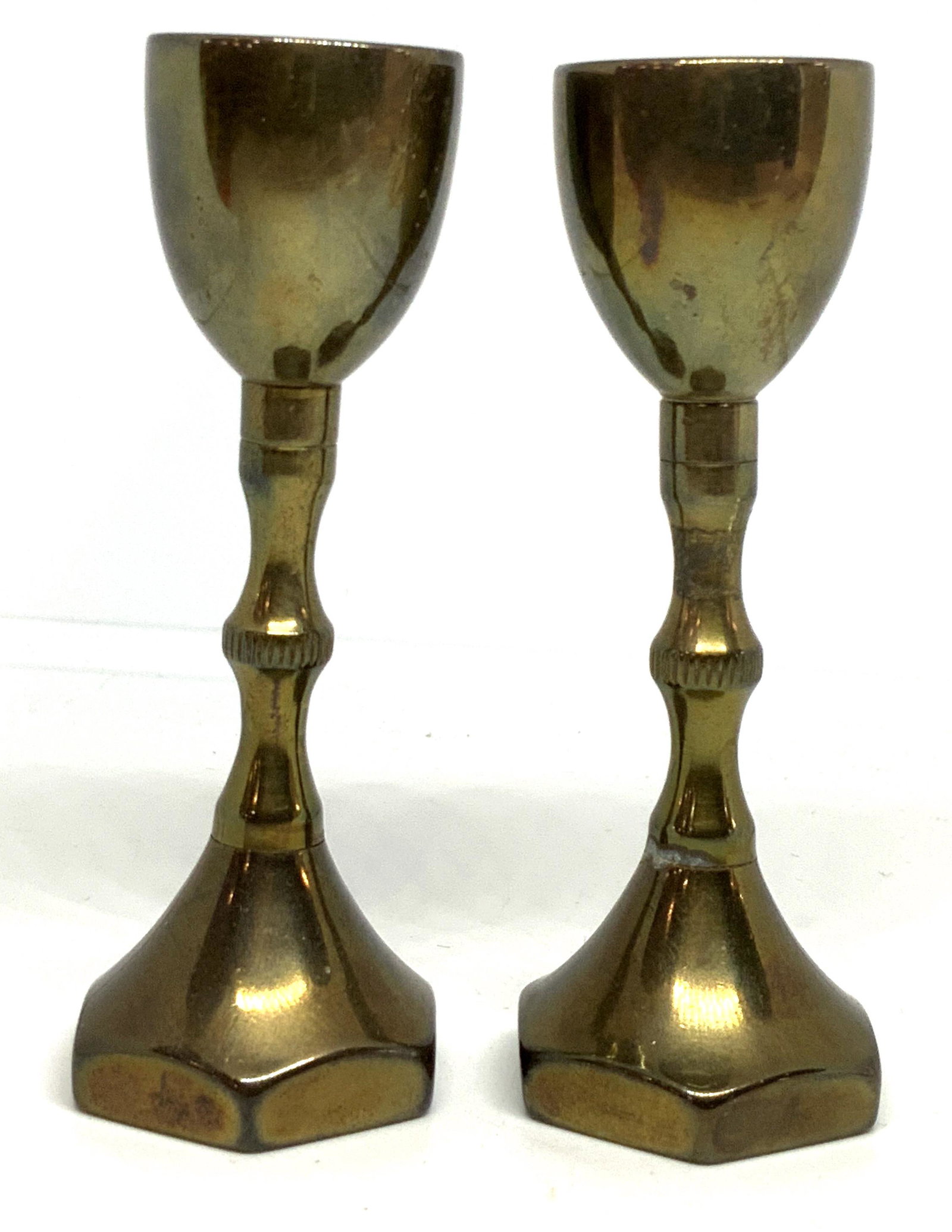Pair Petite Brass Chalices Vessels: Lot includes 2 vessels. Each have chalice shape. Pieces are petite in size. Each vessel appears to be solid brass. Bases are hexagon shaped. Each measures approx 3.25 inches tall 1 inches wide. Each a