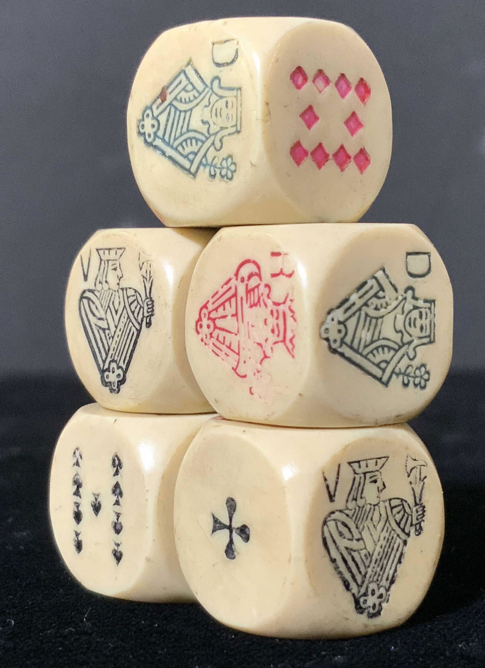 Set 5 Vintage Six Sided Poker Dice: Five dice with etched symbols on all six sides. Possibly vintage. Possibly crafted from bone or resinous material. Colors include black, green, and red hues. Mild wear due to age and use. Approx. .5 x