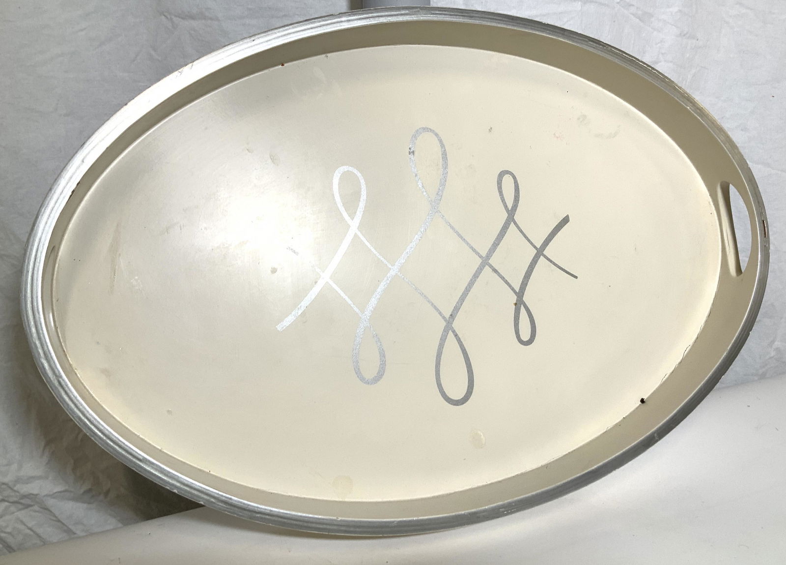 BARBARA BARRY Grand Oval Wood Tray: Barbara Barry Script Transitional Oval Tray in cream color, side carry handles. Underside signed maker. Height: 2.5 in. Width: 24 in. , Depth: 15.75 in. Property of Janine Metz estate, Social Secretar